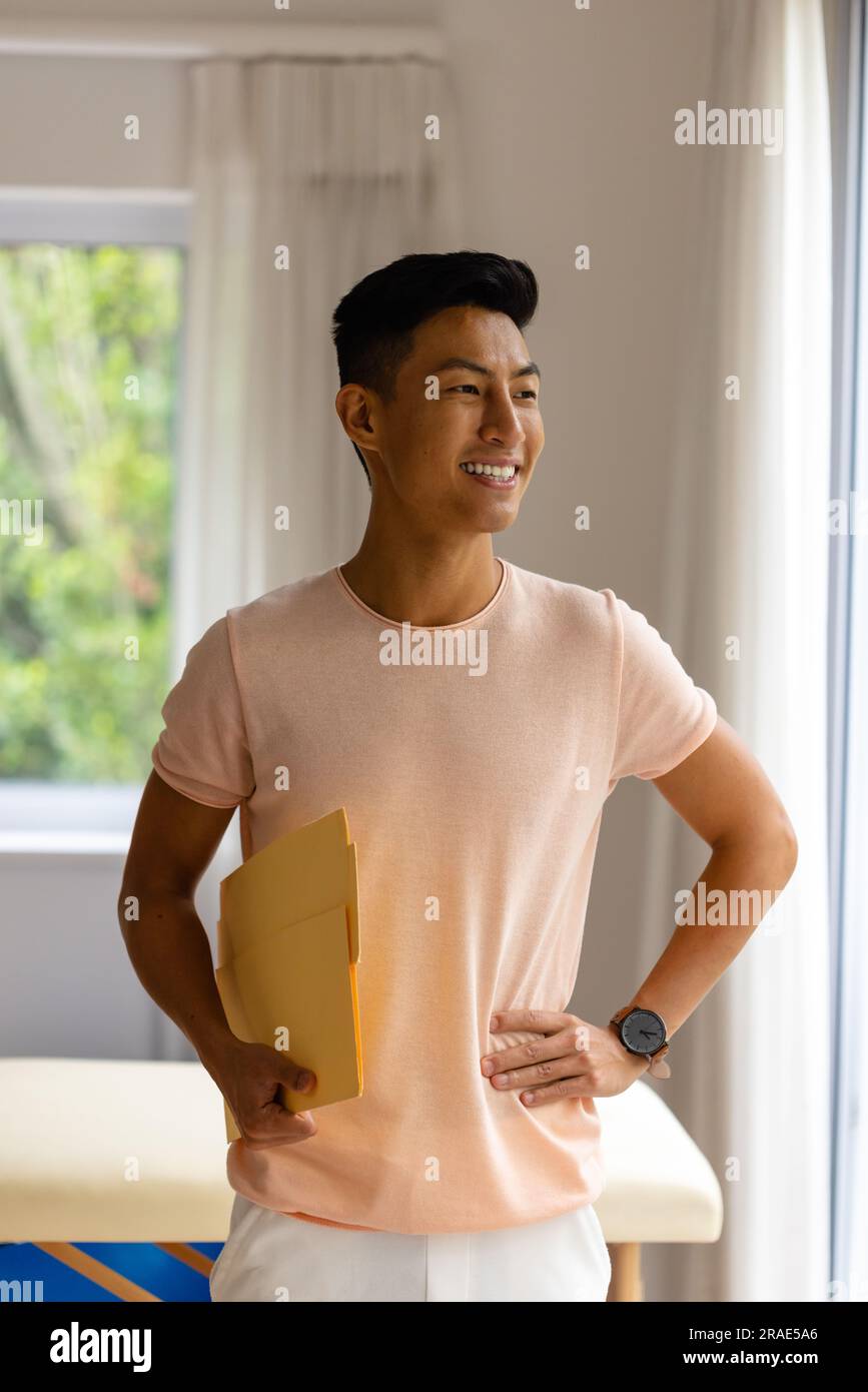 Ritratto di un uomo asiatico felice in una stanza luminosa Foto Stock