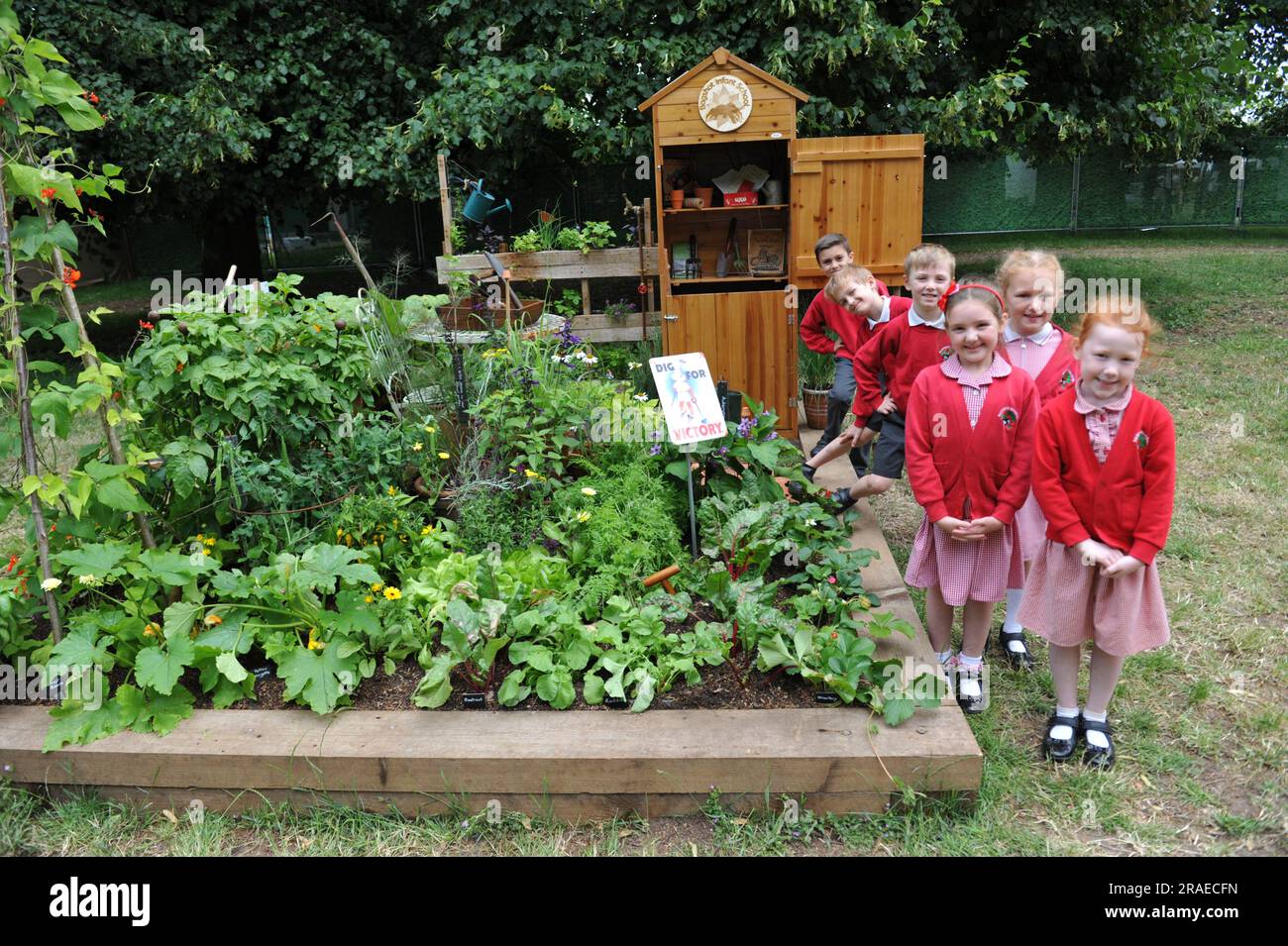 Bambini della Bagshot Infant School con il loro Dig for Victory allotment Garden al 2023 Royal Horticultural Society Hampton Court Palace Garden Festival. I terreni della scuola sono stati convertiti in quote durante entrambe le guerre mondiali, e il giardino riflette questo patrimonio bellico. Nel 2014, la scuola ha ricreato gli spazi di assegnazione, sviluppando la terra in una fiorente risorsa di apprendimento e un'impresa comunitaria autofinanziata, vendendo prodotti realizzati con frutta e verdura del giardino. L'Hampton Court Palace Garden Festival, che si tiene dal 1993, è il fiore e il giardino più prestigiosi Foto Stock