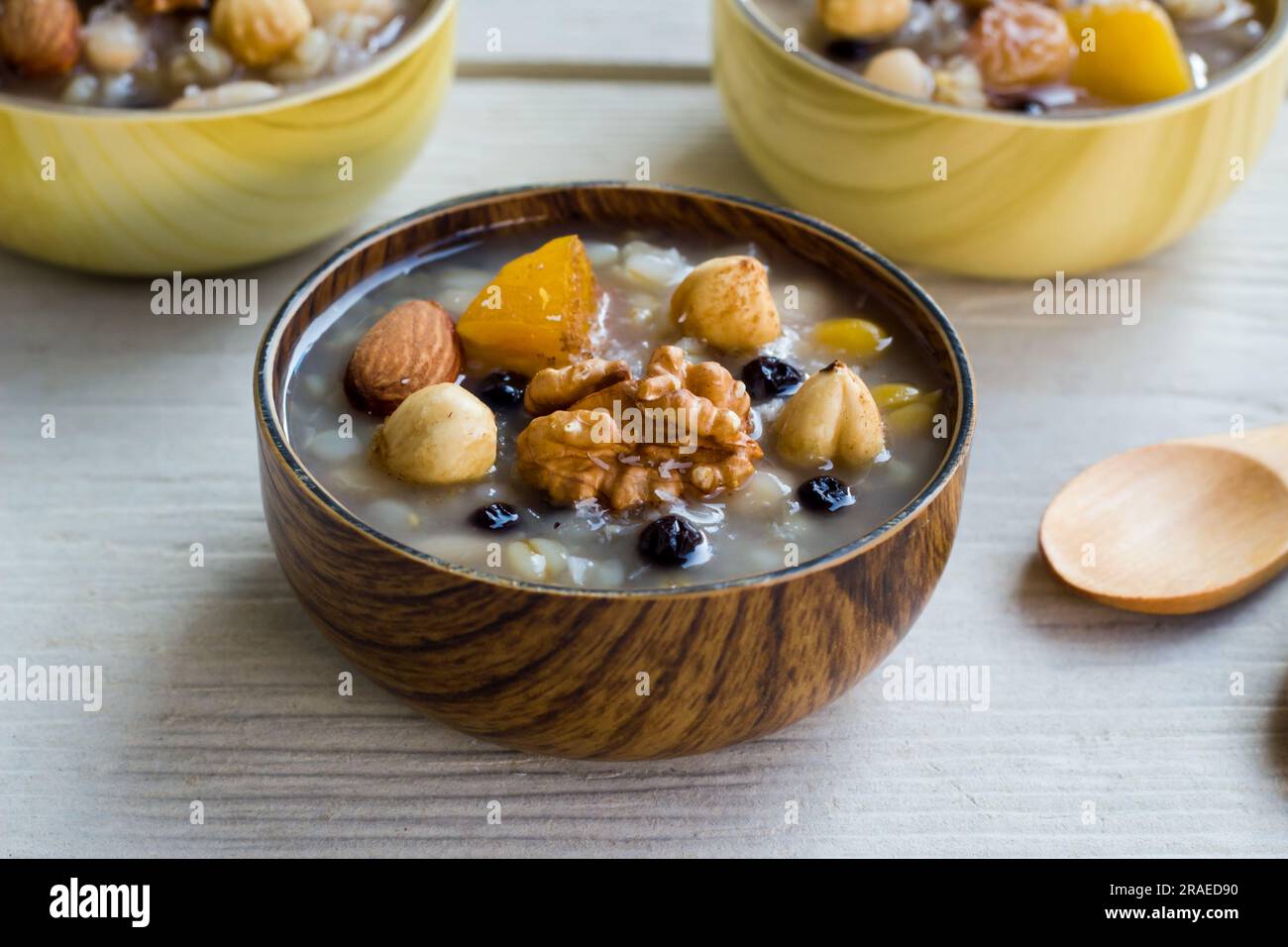 Tradizionale dessert turco Ashure o Noè's Puding in ciotole di bambù su superficie di legno Foto Stock