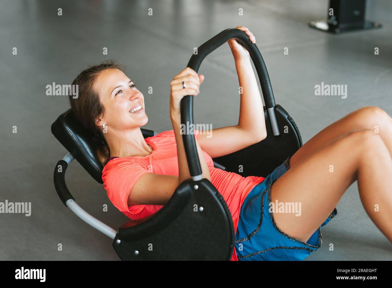 Bella giovane donna in forma che si allena muscoli addominali abs in palestra fitness utilizzando la macchina Foto Stock