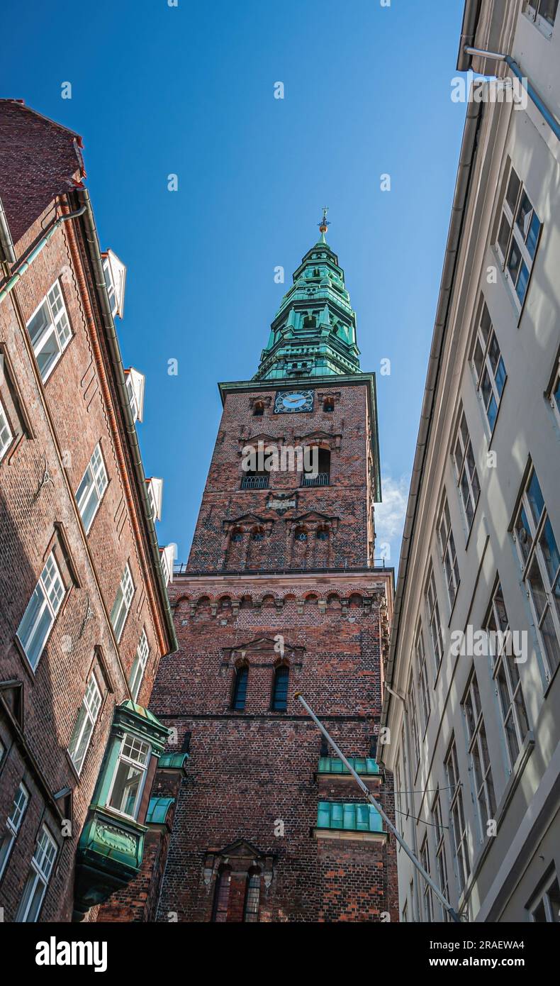 Copenaghen, Danimarca - 15 settembre 2010: Nikolaj Kunsthallen, ex chiesa di Nicola, torre dell'orologio barocco in mattoni rossi con guglia verde sulla sommità di aga Foto Stock