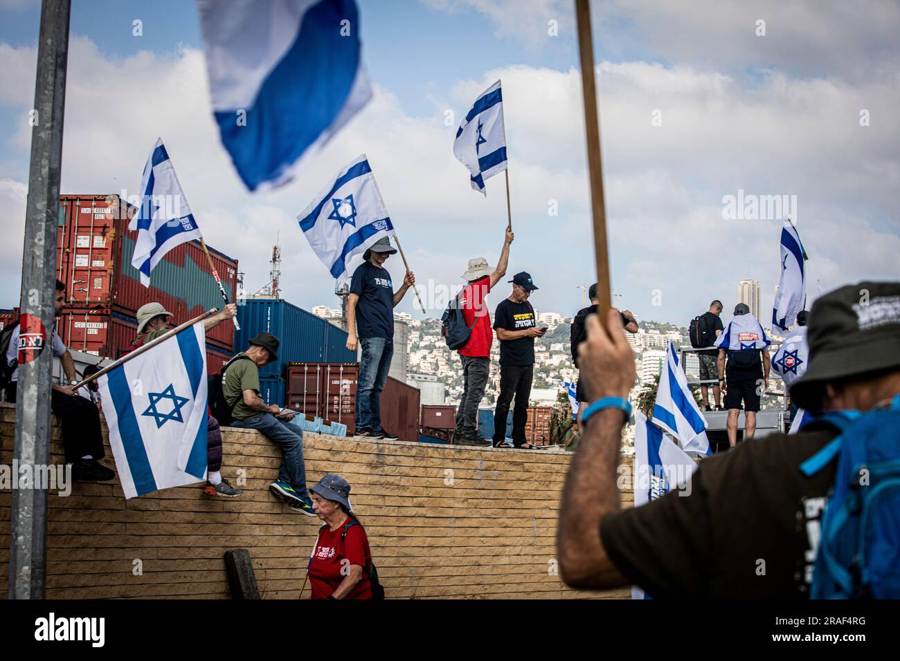 Haifa, Israele. 3 luglio 2023. I manifestanti sventolano le bandiere israeliane mentre manifestano fuori dal porto marittimo di Haifa. Promettendo di andare avanti con una giornata di proteste pianificate nonostante Israele lanci una grande operazione militare nella città della Cisgiordania di Jenin, i manifestanti contro lo sforzo del governo di rivedere il sistema giudiziario hanno bloccato l'accesso al porto di Haifa, dato che decine di raduni si sono svolti anche all'estero. Credito: SOPA Images Limited/Alamy Live News Foto Stock