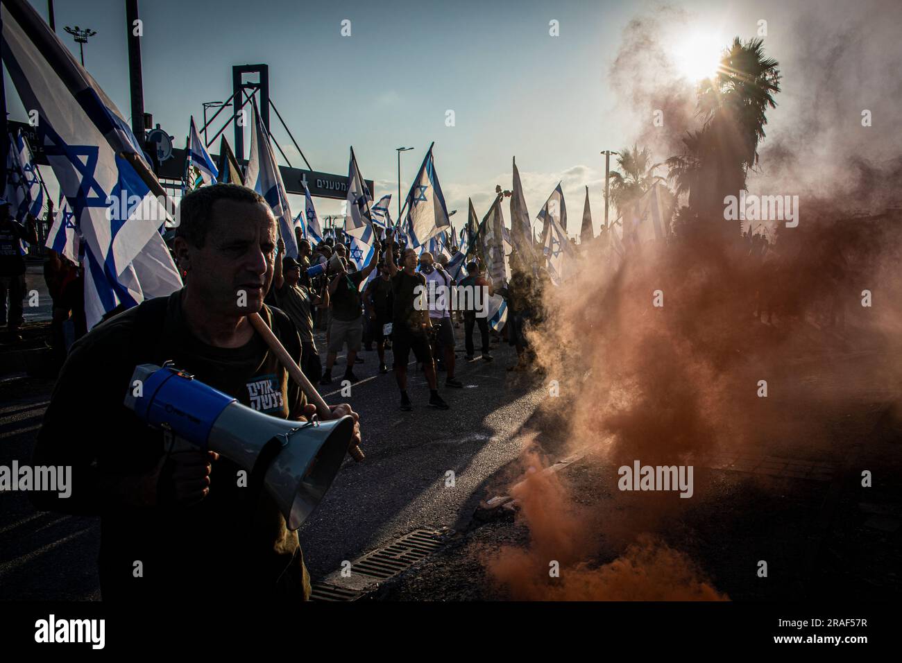 I manifestanti tengono le bandiere israeliane durante la manifestazione fuori dal porto marittimo di Haifa. Promettendo di andare avanti con una giornata di proteste pianificate nonostante Israele lanci una grande operazione militare nella città della Cisgiordania di Jenin, i manifestanti contro lo sforzo del governo di rivedere il sistema giudiziario hanno bloccato l'accesso al porto di Haifa, dato che decine di raduni si sono svolti anche all'estero. (Foto di Eyal Warshavsky / SOPA Images/Sipa USA) Foto Stock