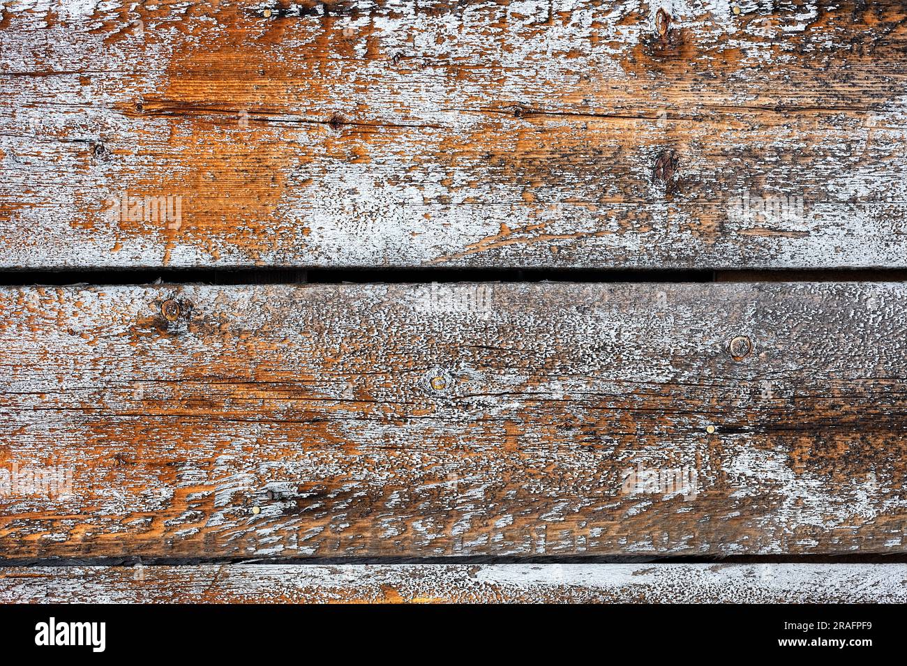 Sfondo, consistenza di vecchie tavole di legno marrone con tracce di vernice bianca sbucciante. Foto Stock