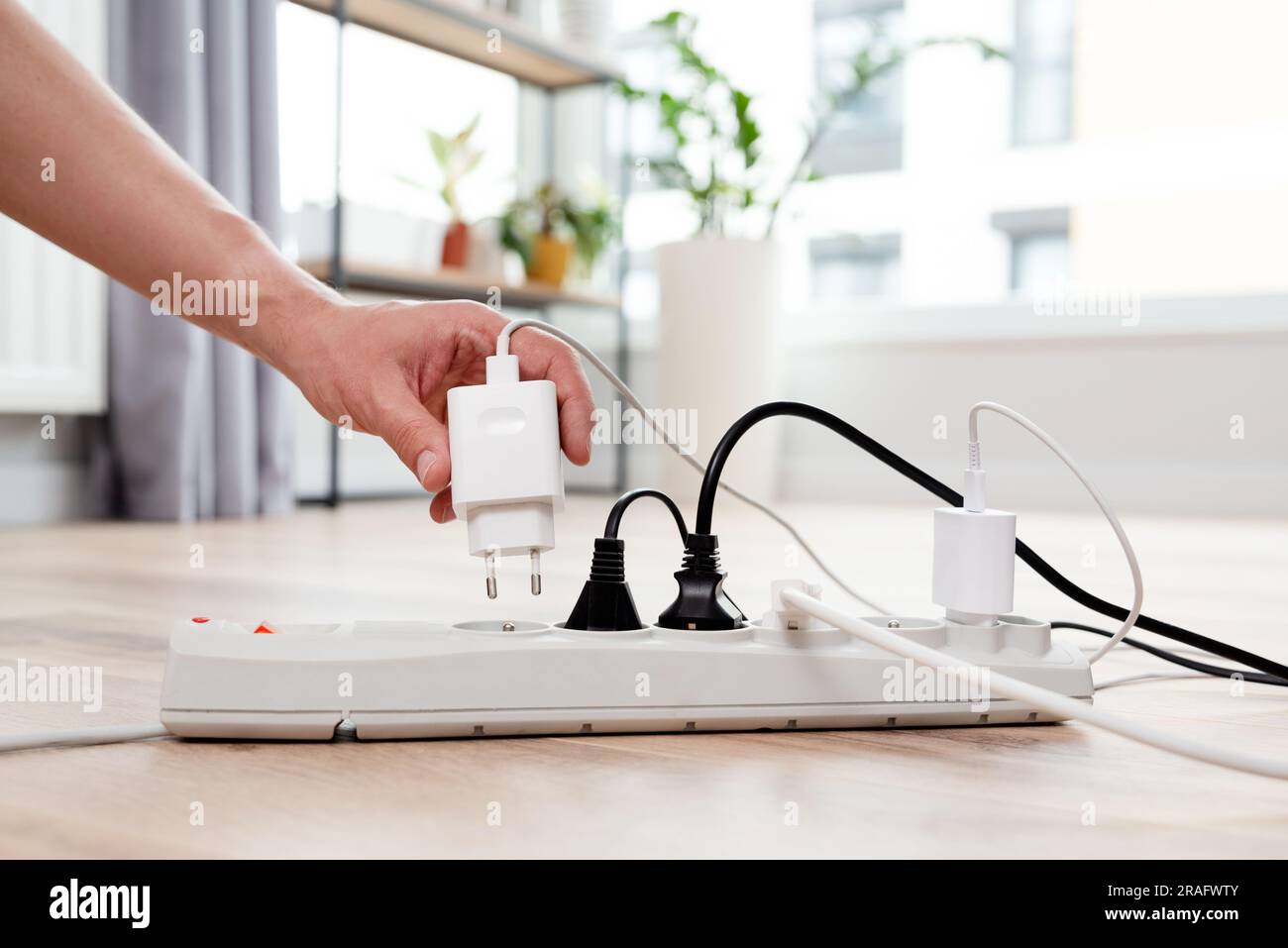 Spina elettrica nella presa di corrente a casa. Concetto di efficienza energetica Foto Stock
