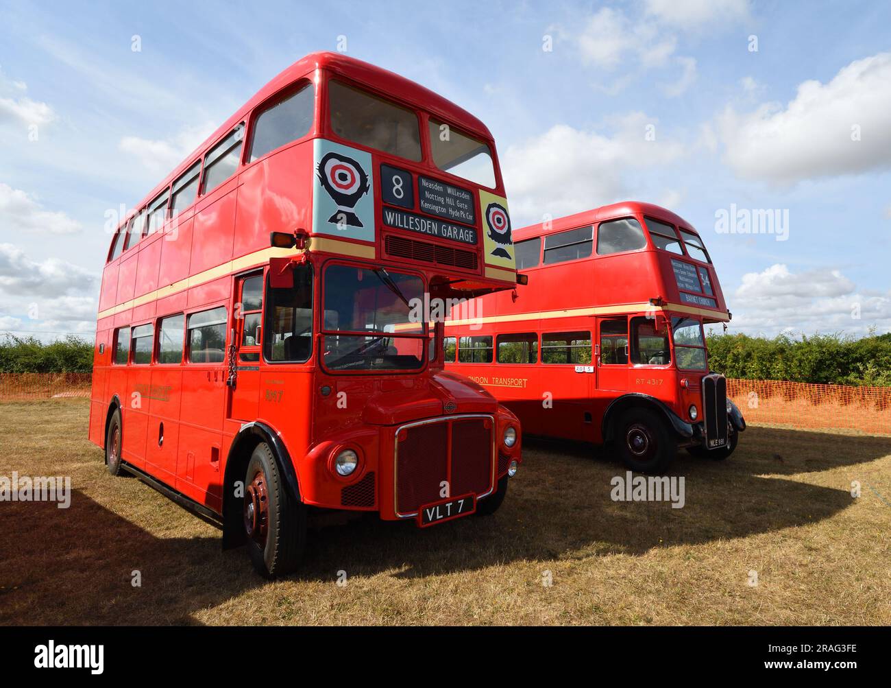 Due autobus vintage a due piani rossi parcheggiati sull'erba. Foto Stock