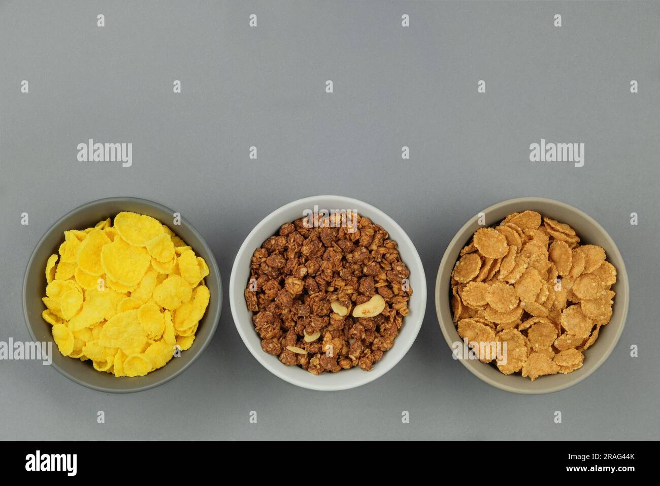 Cereali da colazione in ciotole su sfondo grigio. Fast food. Vista dall'alto. Spazio per il testo. Foto Stock
