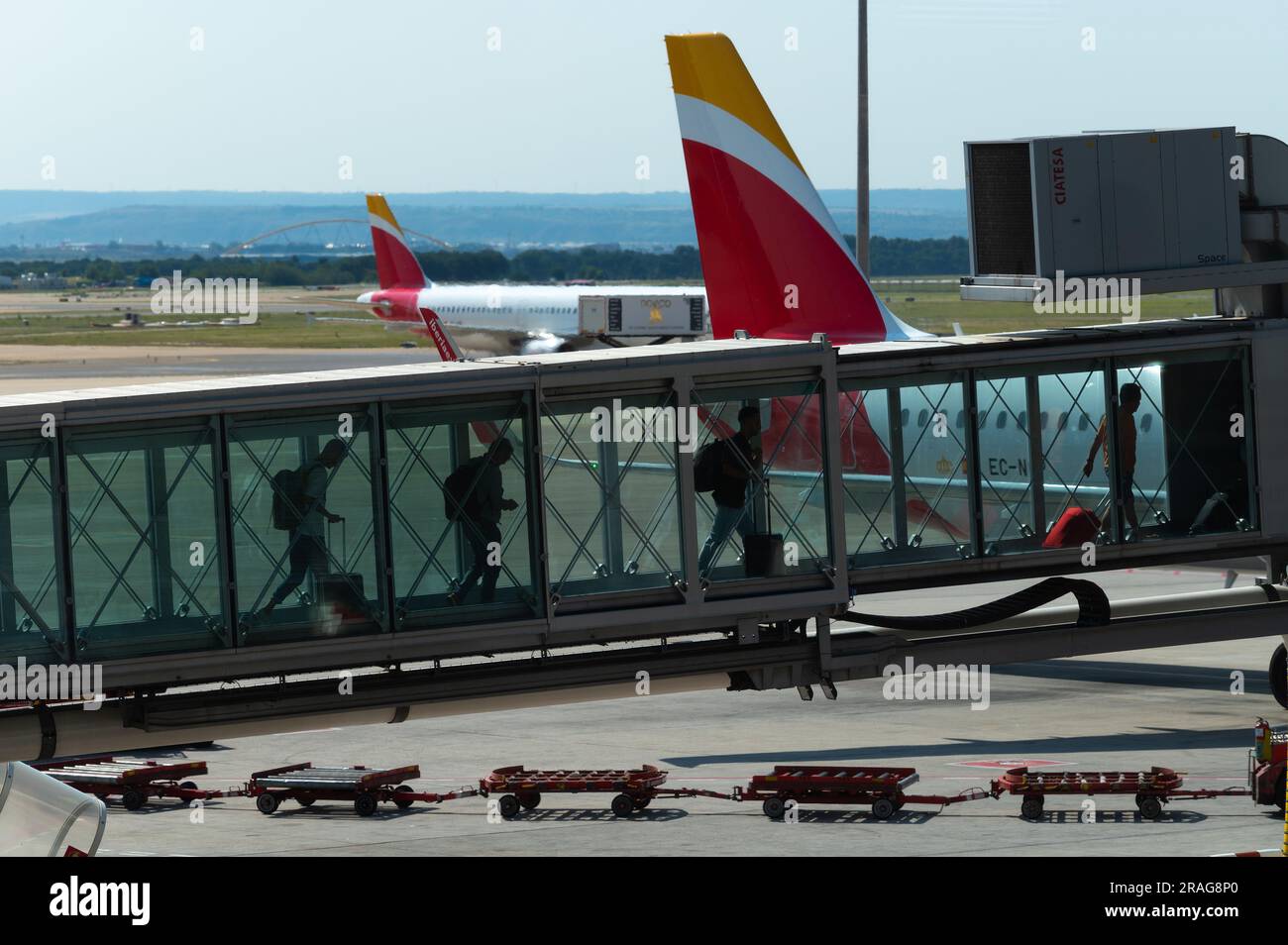 I turisti che trasportano i loro bagagli arrivano da un aereo Iberia all'aeroporto Adolfo Suarez Madrid Barajas. Foto Stock