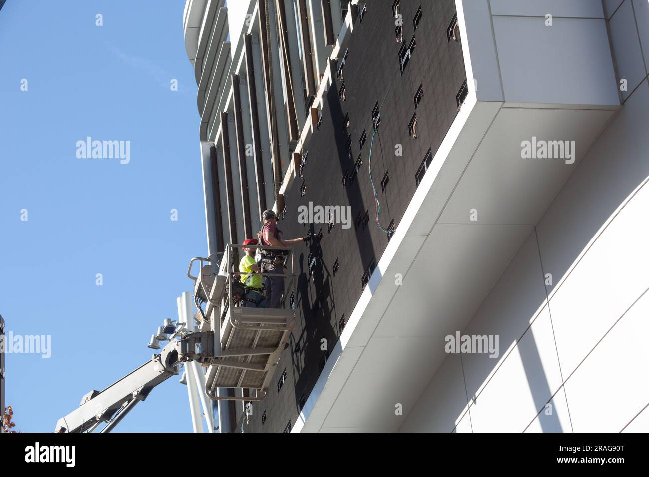 Lavoratori che cambiano il cartello sopra Tom's Urban a Los Angeles Vive nel centro di Los Angeles, CALIFORNIA, USA Foto Stock