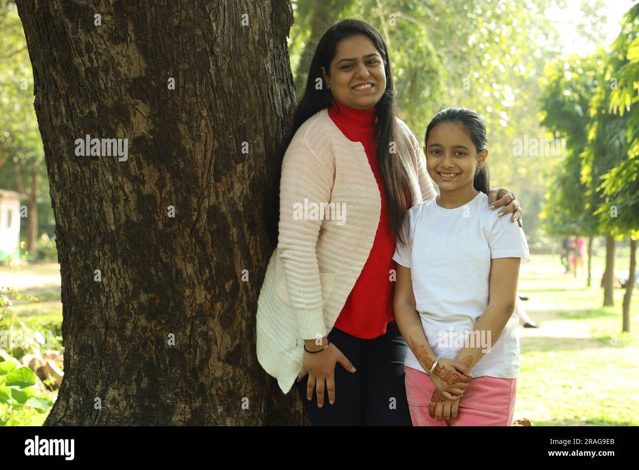 Madre e figlia indiane che si divertono insieme nel parco di giorno. La figlia è amata e si sente al sicuro con sua madre. Foto Stock