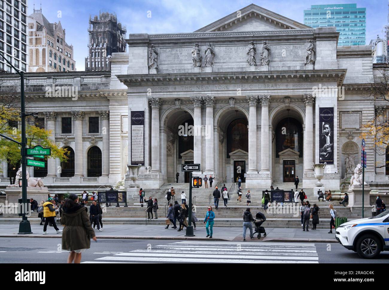 Scena stradale trafficata con pedoni di fronte all'edificio della New York Public Library sulla Fifth Avenue Foto Stock