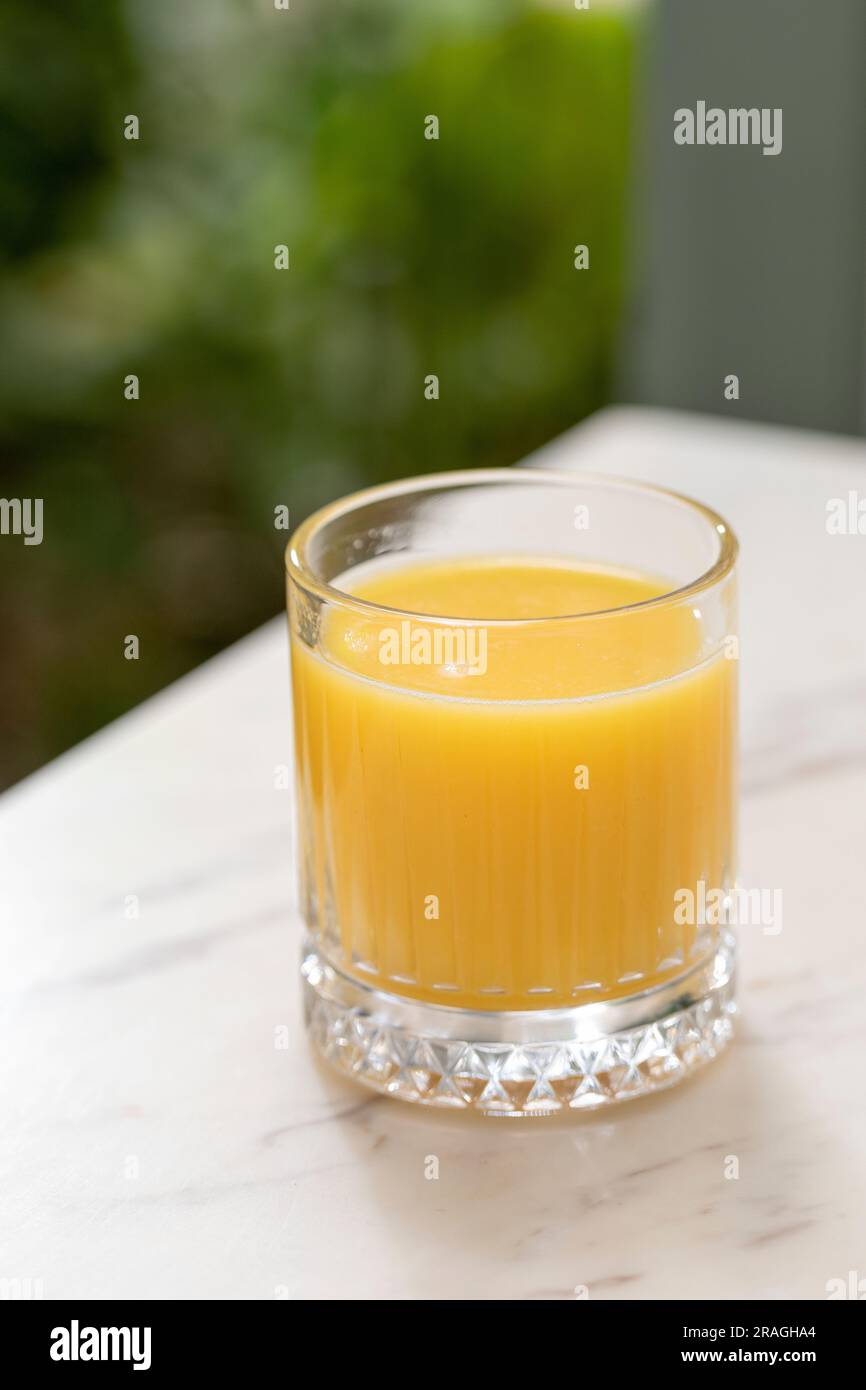 succo d'arancia fresco servito in un tavolo di marmo Foto Stock
