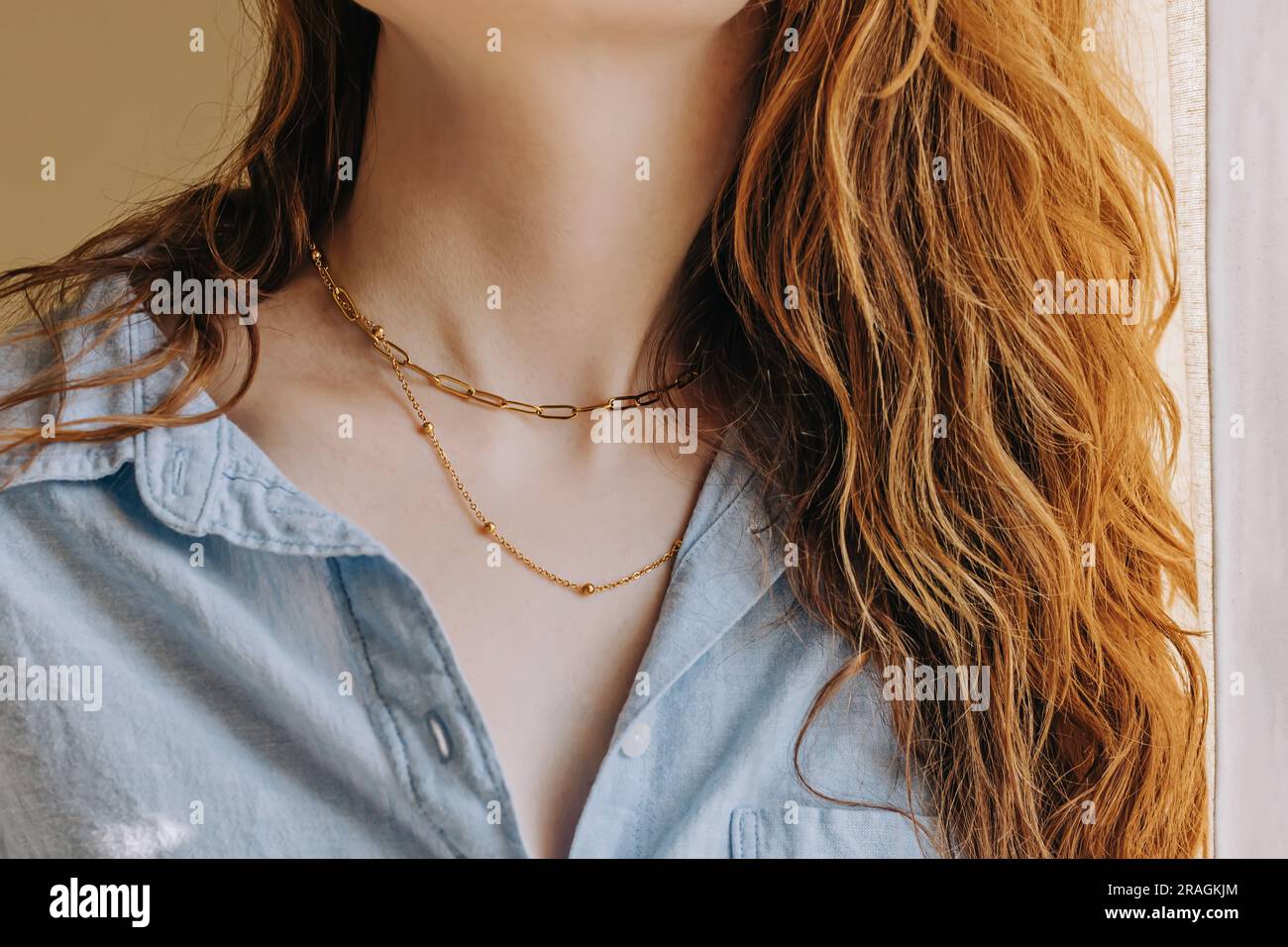 Primo piano del collo femminile con un'elegante collana con catena dorata Foto Stock