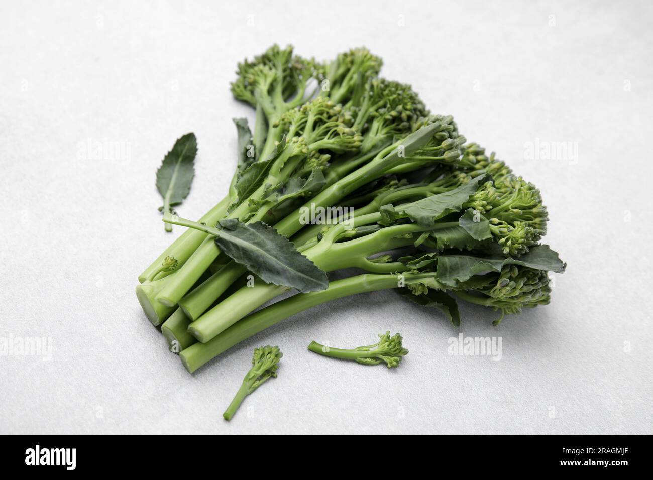 Broccolini crudi freschi su sfondo bianco. Cibo sano Foto Stock