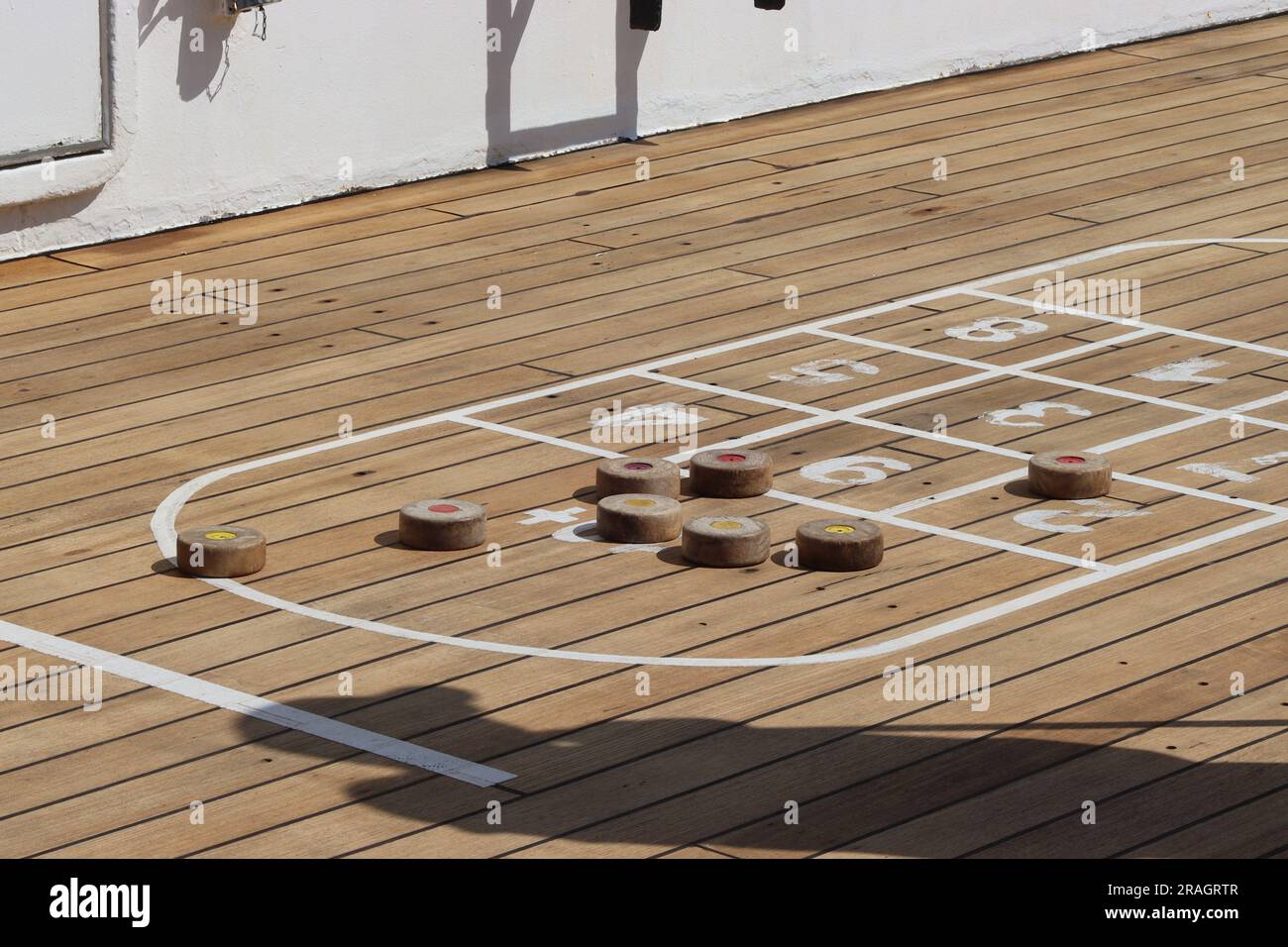 I giocatori valutano il punteggio durante una gara di shuffleboard a bordo di una partita di shuffleboard sul ponte Sun della nave da crociera Arcadia, aprile 2023. Foto Stock