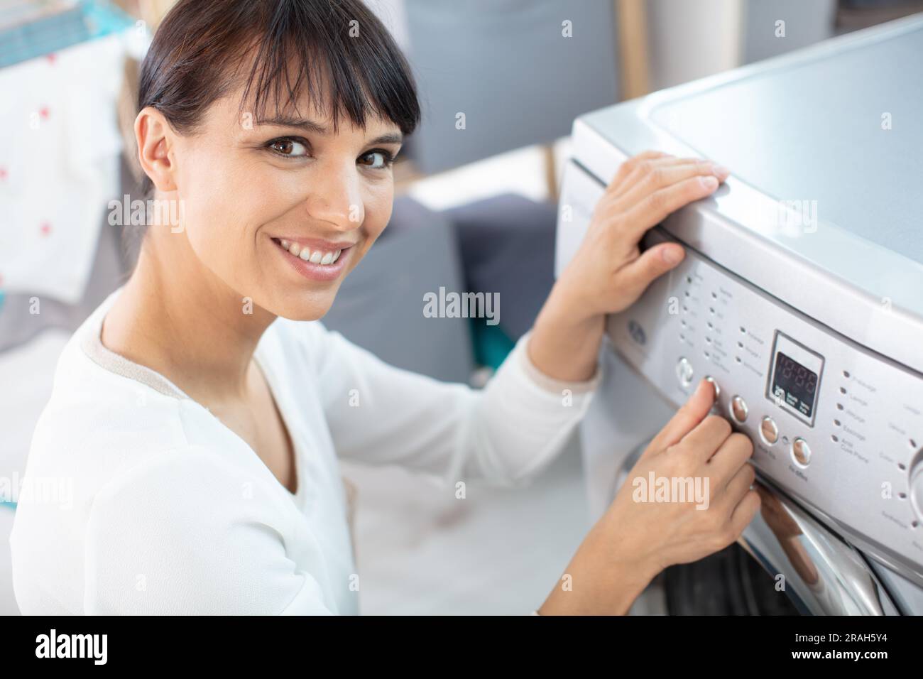 Bella ragazza sorridente nel servizio lavanderia Sala l Foto Stock