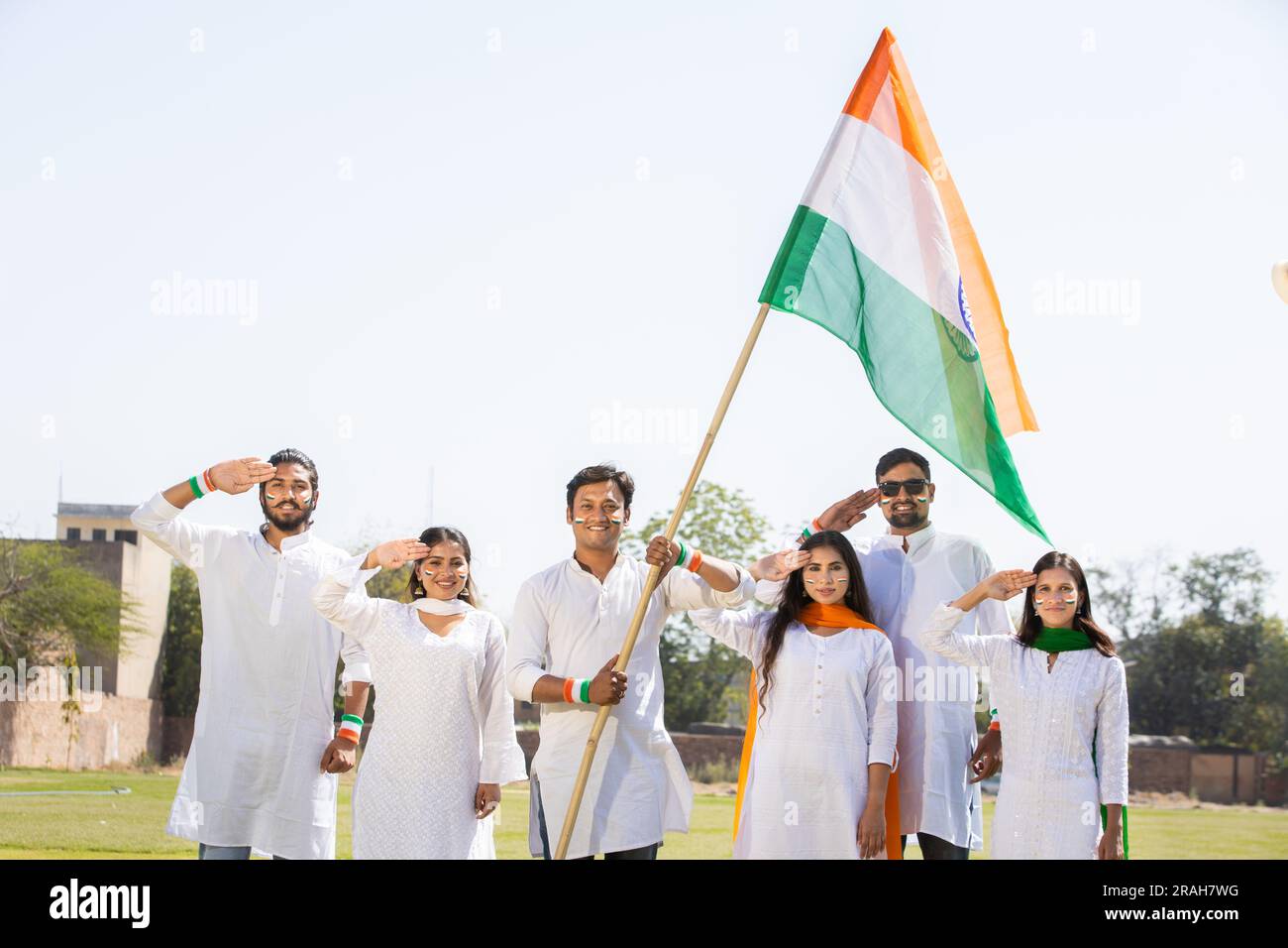 Gruppo di giovani felici che indossano un tradizionale vestito bianco con bandiera indiana per celebrare il giorno dell'indipendenza o il giorno della Repubblica. Foto Stock