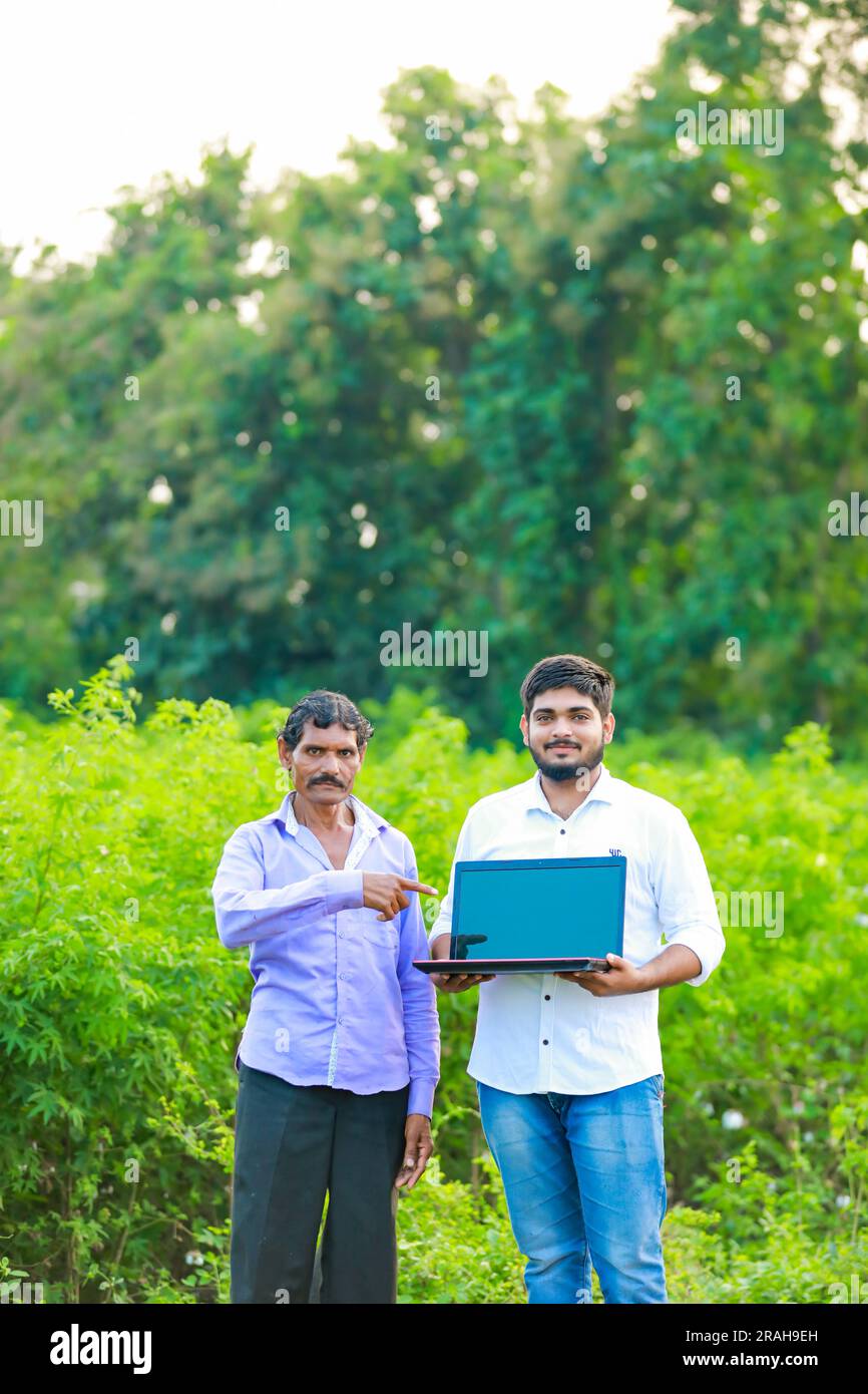 Agricoltore indiano che tiene un portatile, agricoltura intelligente Foto Stock