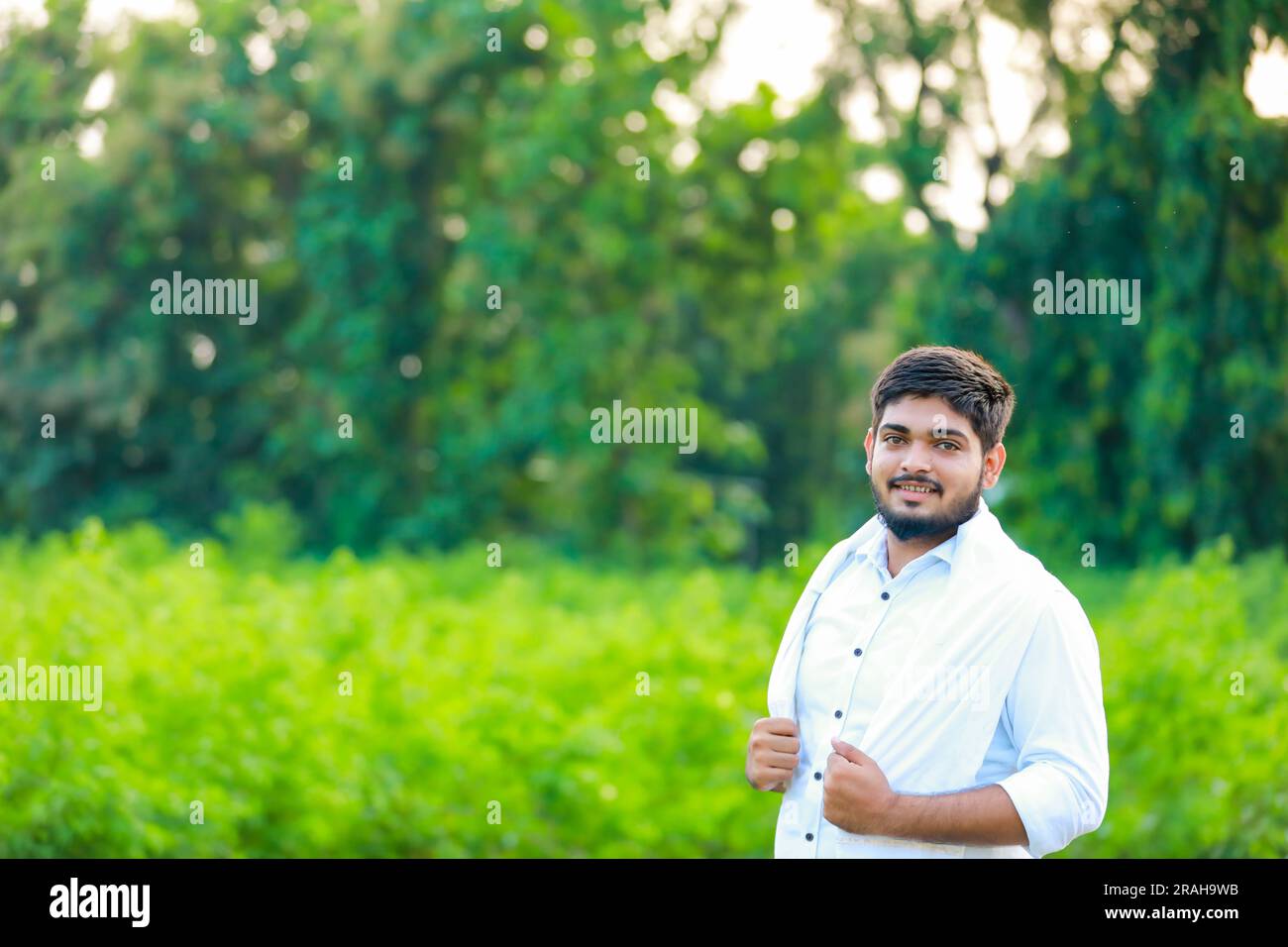 Contadino indiano che tiene il cotone in mano , felice e giovane agricoltore Foto Stock