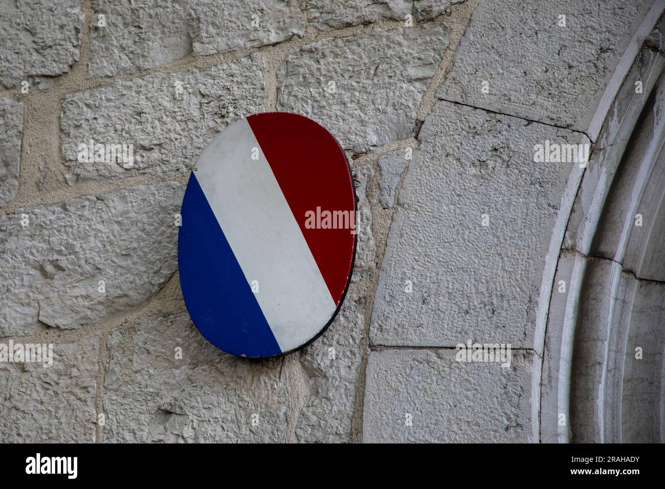 bandiera francese, pannello rotondo blu, bianco e rosso sull'edificio ufficiale della parete d'ingresso Foto Stock