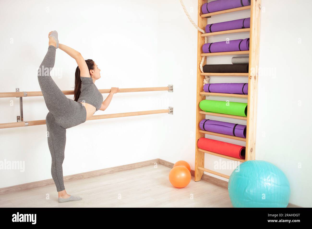 la giovane donna fa ginnastica in palestra. Stile di vita sano. alzate la gamba. Foto Stock