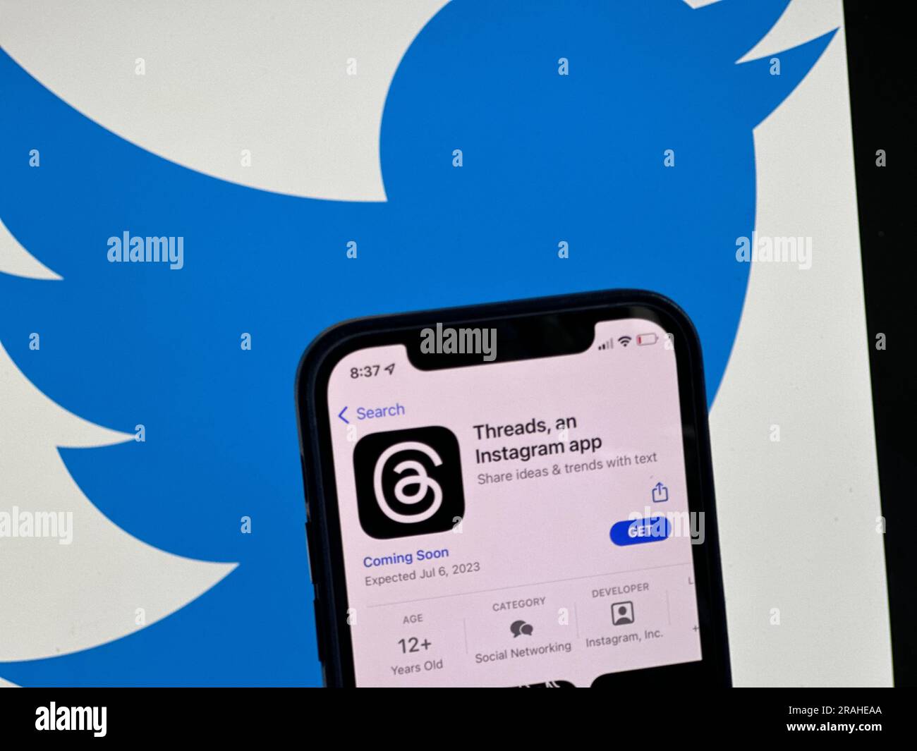 4 luglio 2023, Berlino: L'annuncio dei thread dell'app per i social media viene visualizzato nell'App Store di Apple negli Stati Uniti. Il logo Twitter può essere visto sullo sfondo. L'attesissimo concorrente di Twitter del gruppo Facebook Meta è previsto per il lancio il 6 luglio 2023. (A dpa 'Facebook Group to make Twitter competitor available soon') foto: Christoph Dernbach/dpa Foto Stock