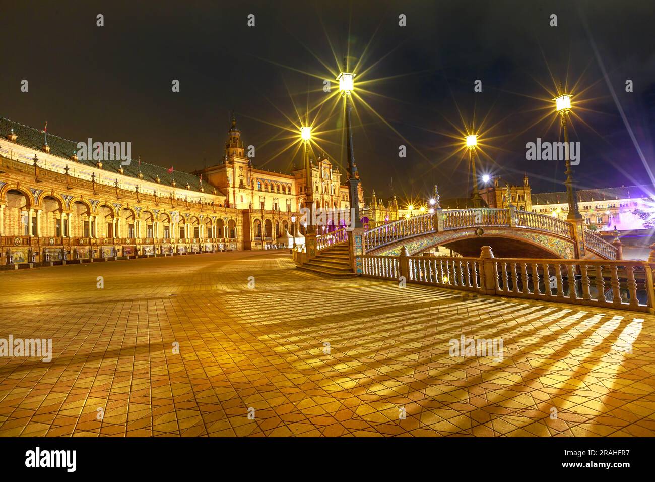 L'edificio rinascimentale centrale di Piazza Spagna, una vista mozzafiato dal Ponte di Leon a Siviglia di notte, il fascino di Plaza de Espana è al centro della scena Foto Stock