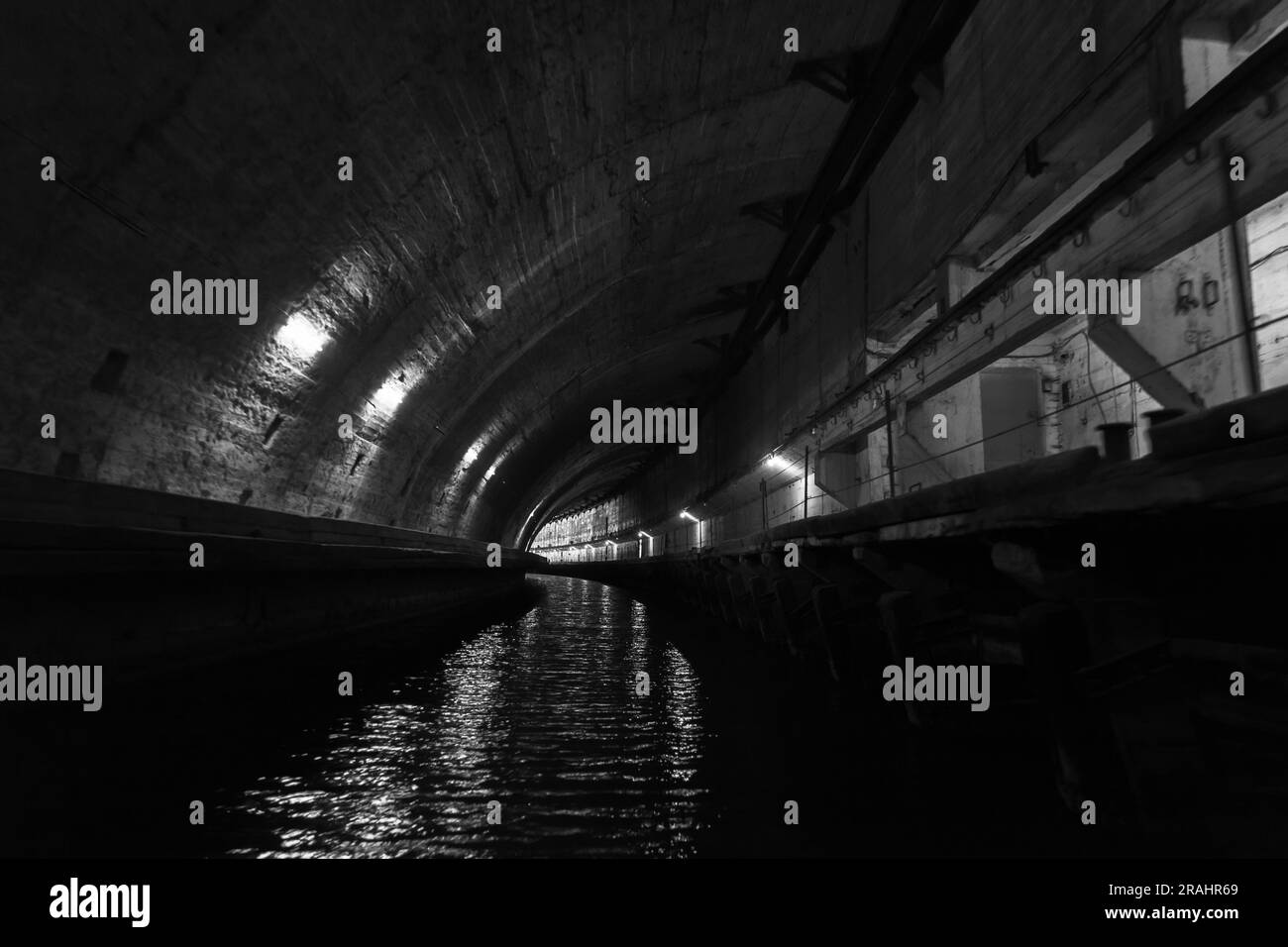 Prospettiva industriale del tunnel in cemento scuro. Base sottomarina sotterranea Aandoned del periodo URSS. Balaklava, Crimea Foto Stock