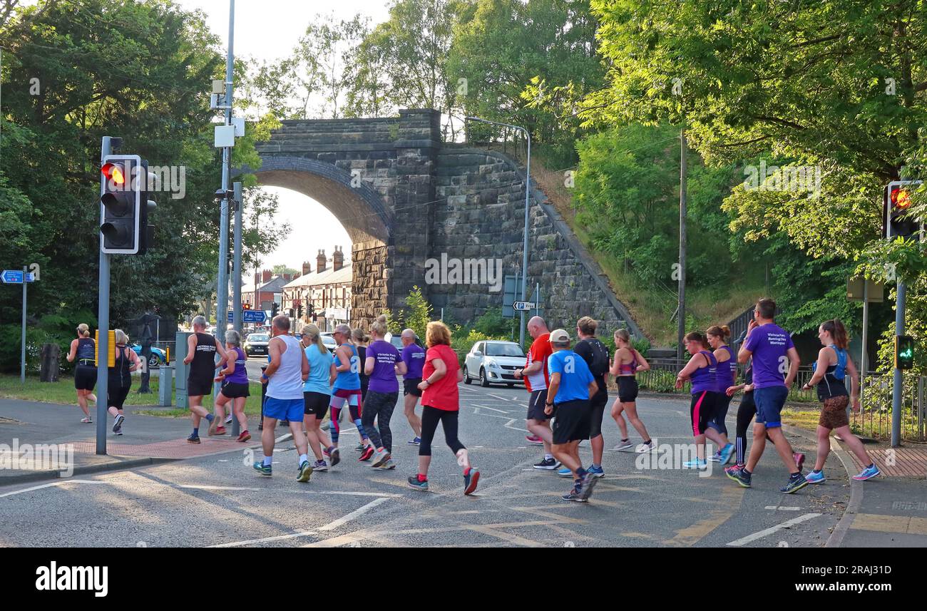 Membri del Victoria Park Running Club Warrington, attraversamento serale di gruppo al 752a Knutsford Rd, Warrington, Cheshire, Inghilterra, Regno Unito, WA4 1JS Foto Stock