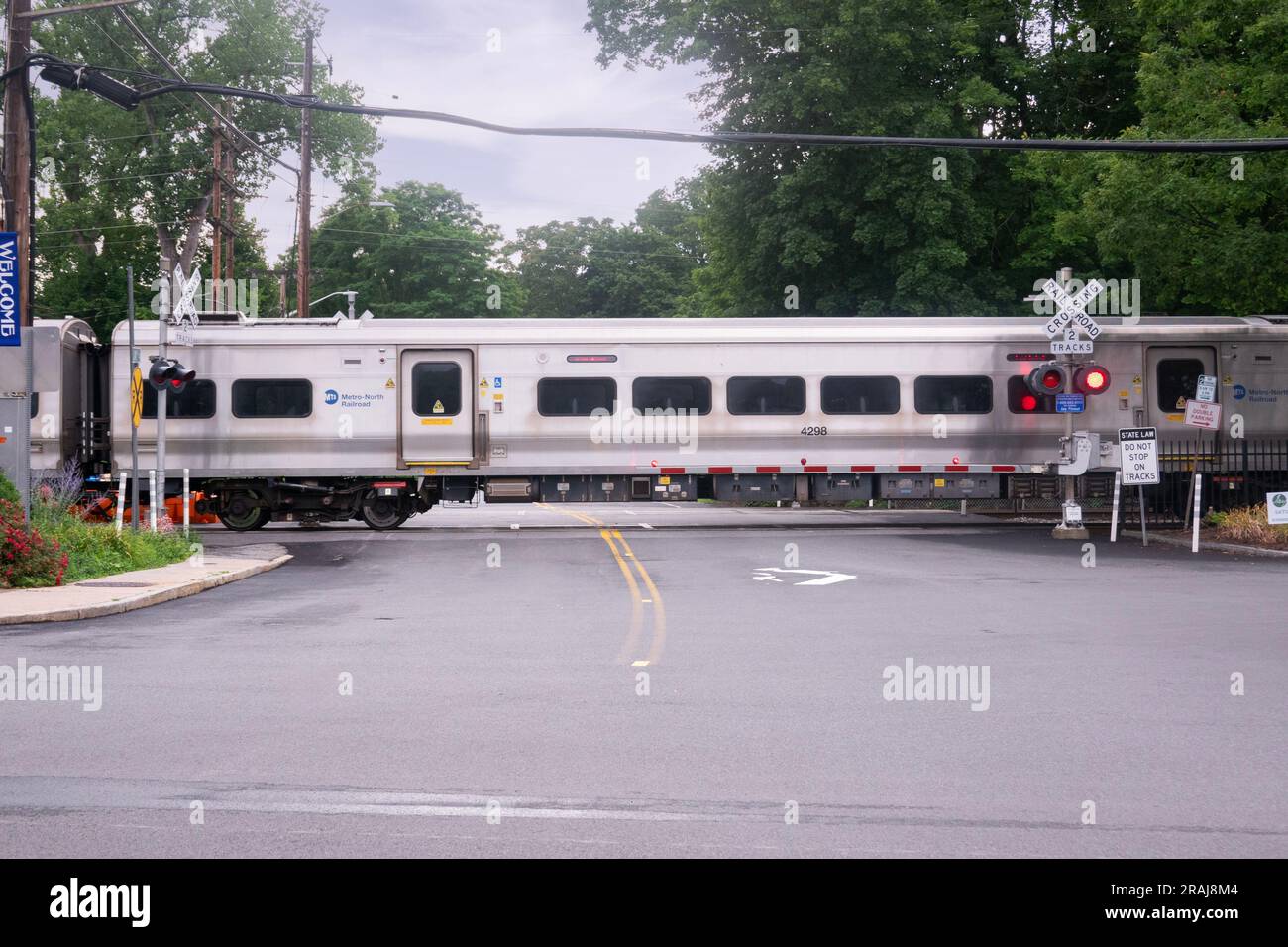 Un treno Metro North parte dalla stazione di Katonah, attraversa Jay St e poi dirigiti a sud verso White Plains e Grand Central Station. A Westchester, New York. Foto Stock