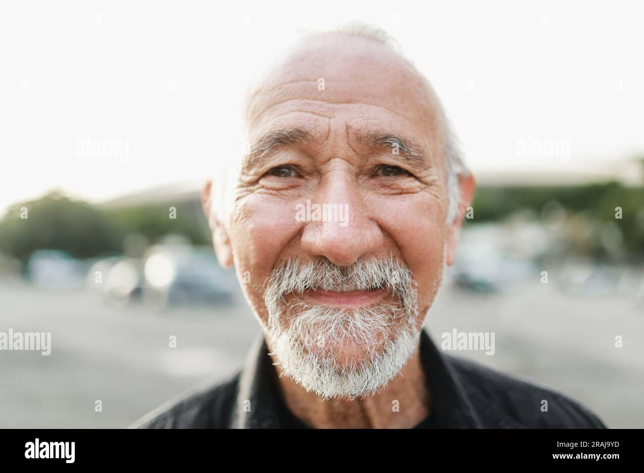 Uomo anziano felice sorridente sulla fotocamera all'aperto - stile di vita anziano - concentrazione principale sul naso Foto Stock