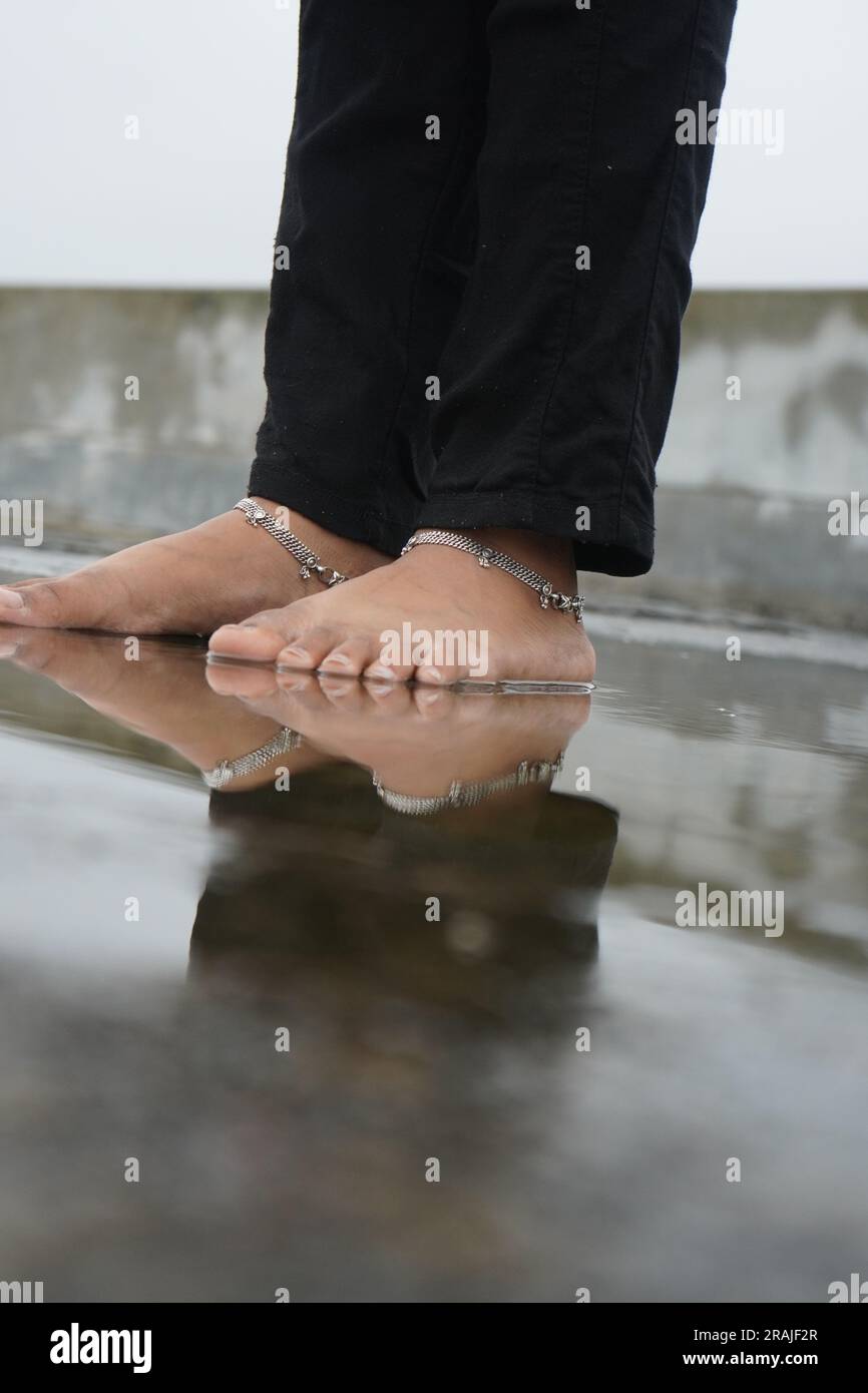 Un piede da ragazza con una catena d'argento sulla caviglia Foto Stock