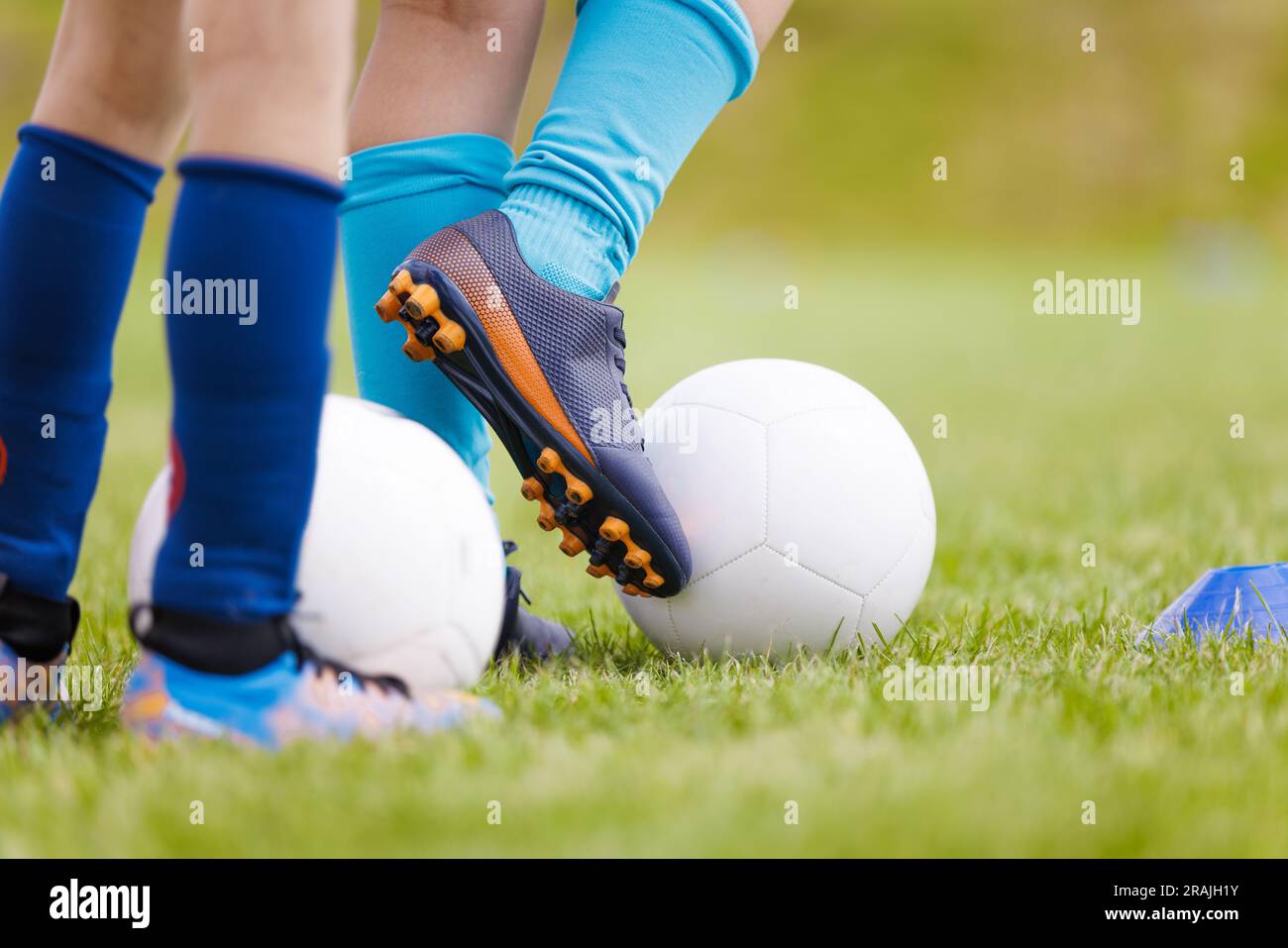 Formazione calcio calcio. Calciatori con palline da calcio sul campo di allenamento. I giocatori di scarpe da calcio che praticano le abilità di dribbling Foto Stock