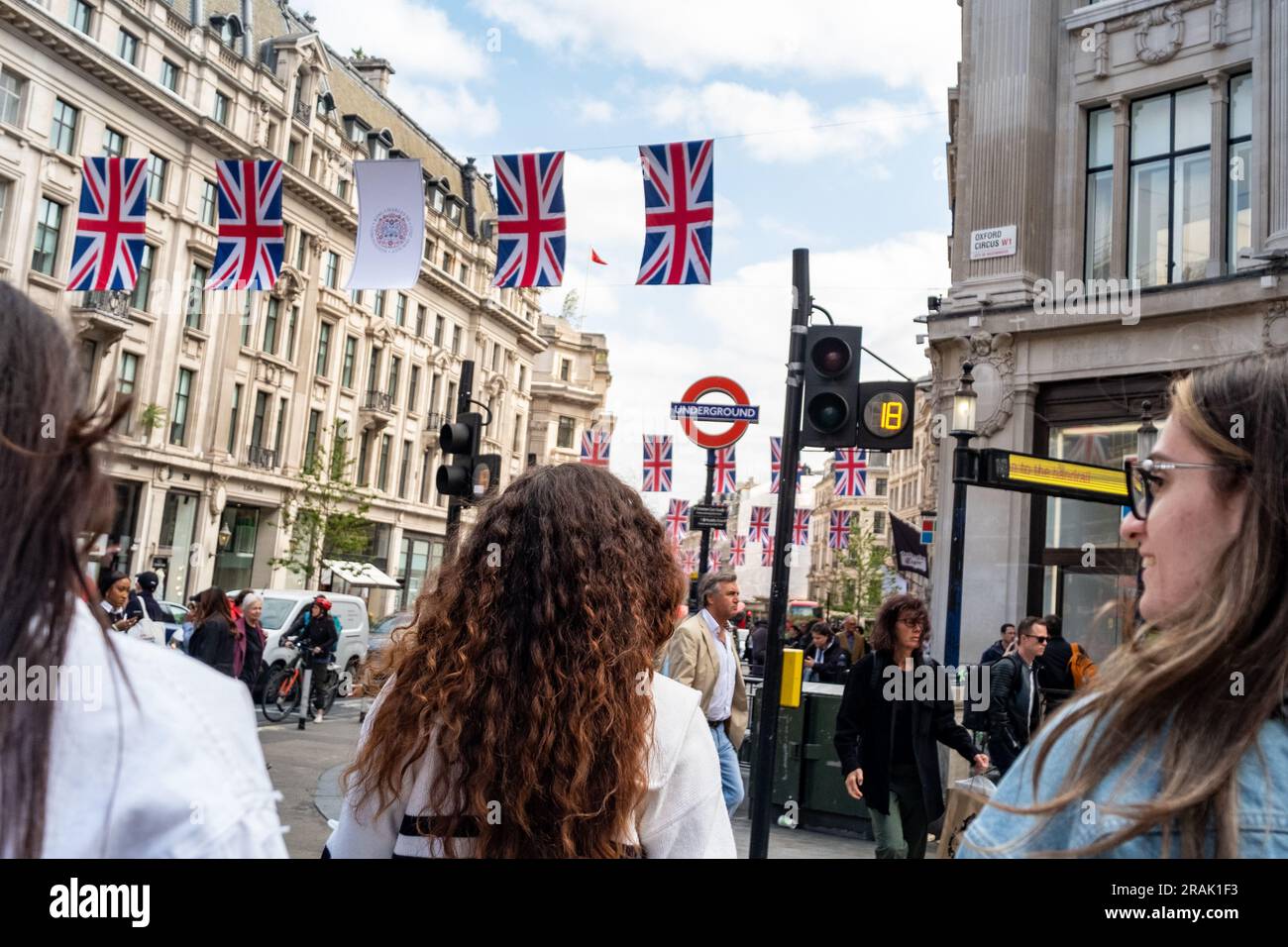 Londra - giugno 2023: Gli amanti dello shopping a Oxford Street con le bandiere della British Union al di sopra di questa destinazione di shopping Foto Stock