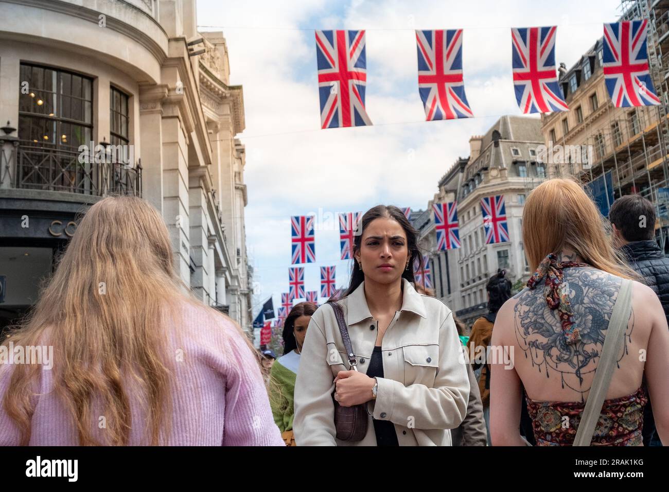 Londra - giugno 2023: Gli amanti dello shopping in Regent Street con bandiere della British Union al di sopra di questa destinazione di shopping Foto Stock