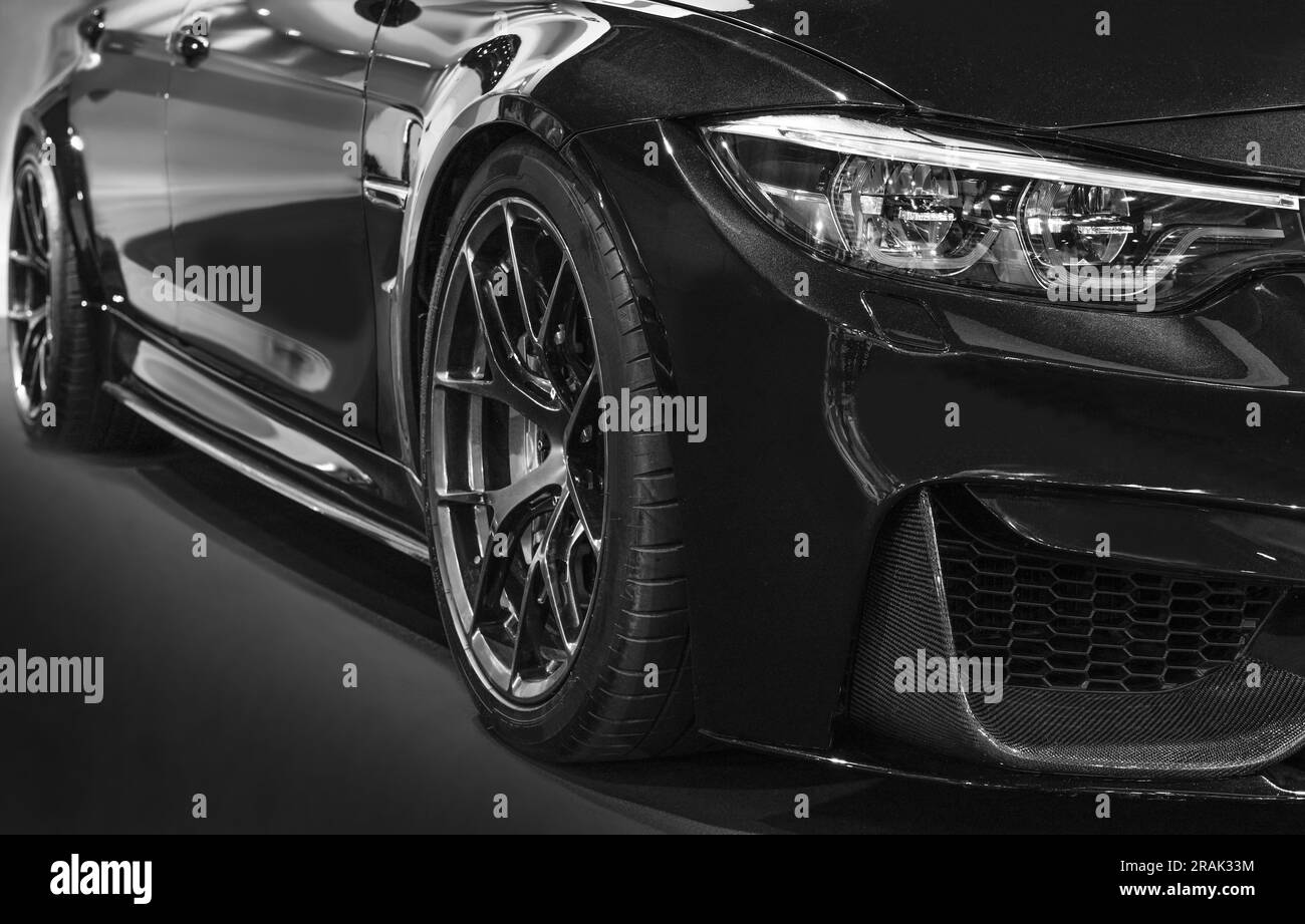 Fari anteriori di auto nera modificata su sfondo nero Foto Stock