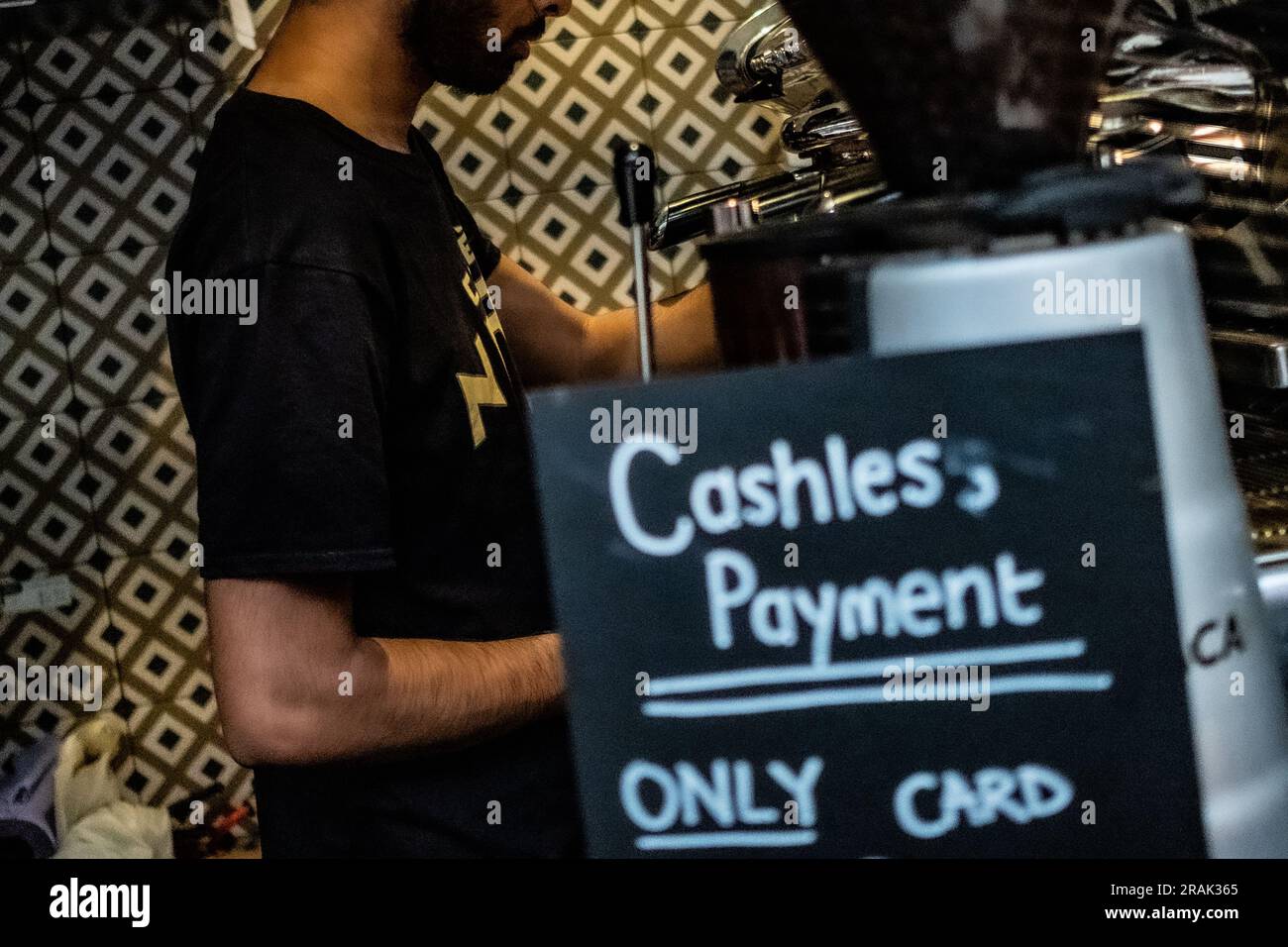 Londra - giugno 2023: Una persona fa un caffè in una caffetteria di Londra con un cartello con scritto "Only Card" e "Cash Payment"- Foto Stock