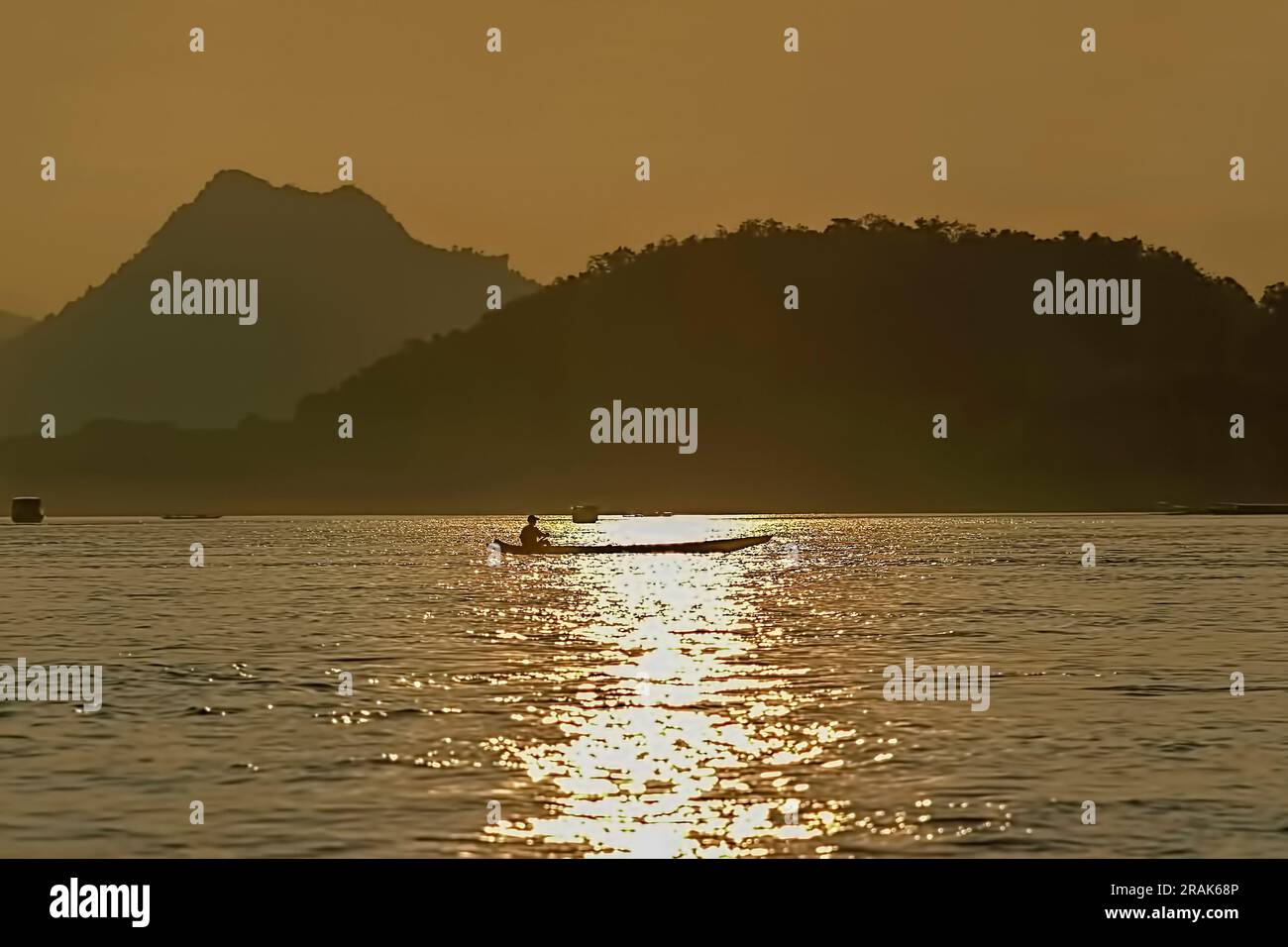 Una barca attraversa il fiume Mekong a Luang Prabang, Laos, durante il tramonto Foto Stock