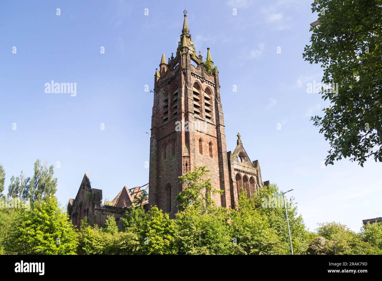 Resti iconici della chiesa parrocchiale di Dundyvan a Coatbridge, Scozia. Una chiesa in rovina e danneggiata dal fuoco in stile gotico Scots Revival in rosso sa Foto Stock