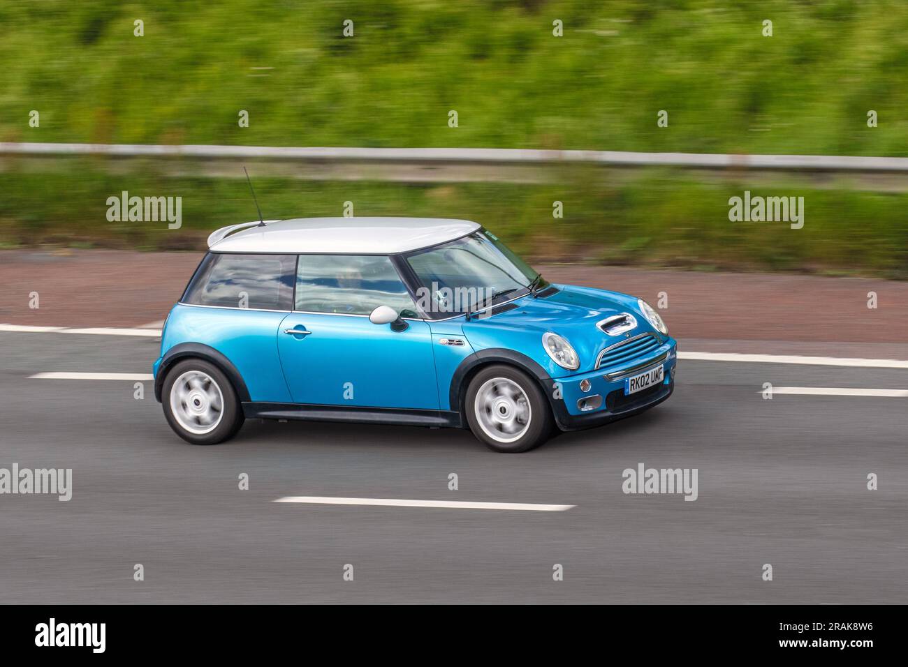 2002 Blue Mini Cooper S Car Hatchback benzina 1598 cc che viaggia a velocità sostenuta sull'autostrada M6 a Greater Manchester, Regno Unito Foto Stock