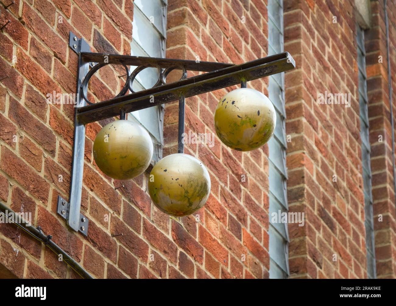 Insegna in metallo Pawnbrokers tradizionale con il simbolo di tre sfere d'oro sospese da Un bar, Kings Lynn, Inghilterra Regno Unito Foto Stock
