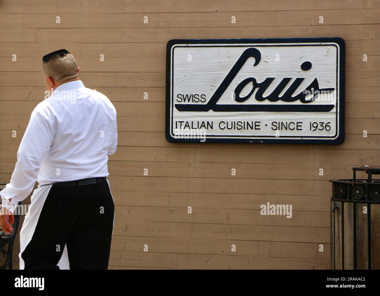 Cartello esterno per ristorante Swiss Louis Italian Seafood con cameriere di passaggio San Francisco California USA Foto Stock