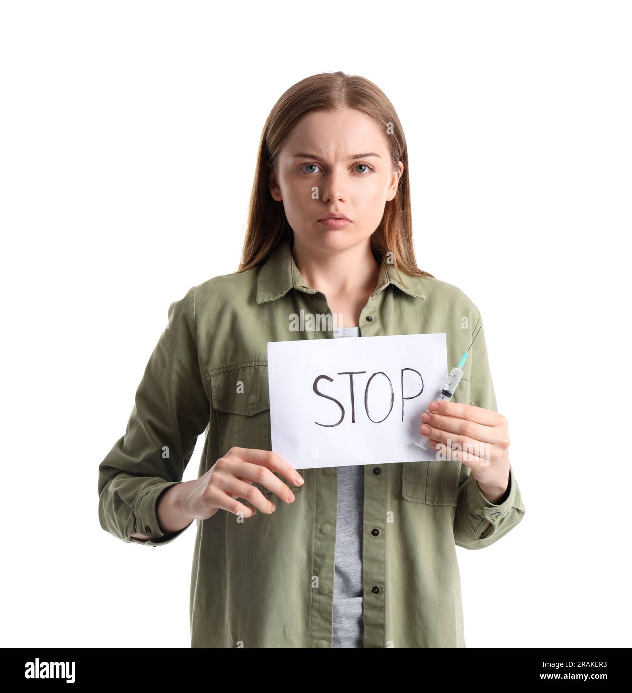 Giovane drogata che tiene siringa e carta con parola STOP su sfondo bianco Foto Stock