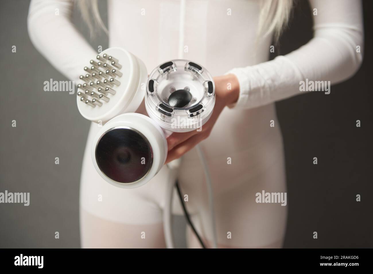 Una donna che mostra gli accessori di una macchina dimagrante alla  cavitazione, al sollevamento rf e al trattamento a vuoto Foto stock - Alamy