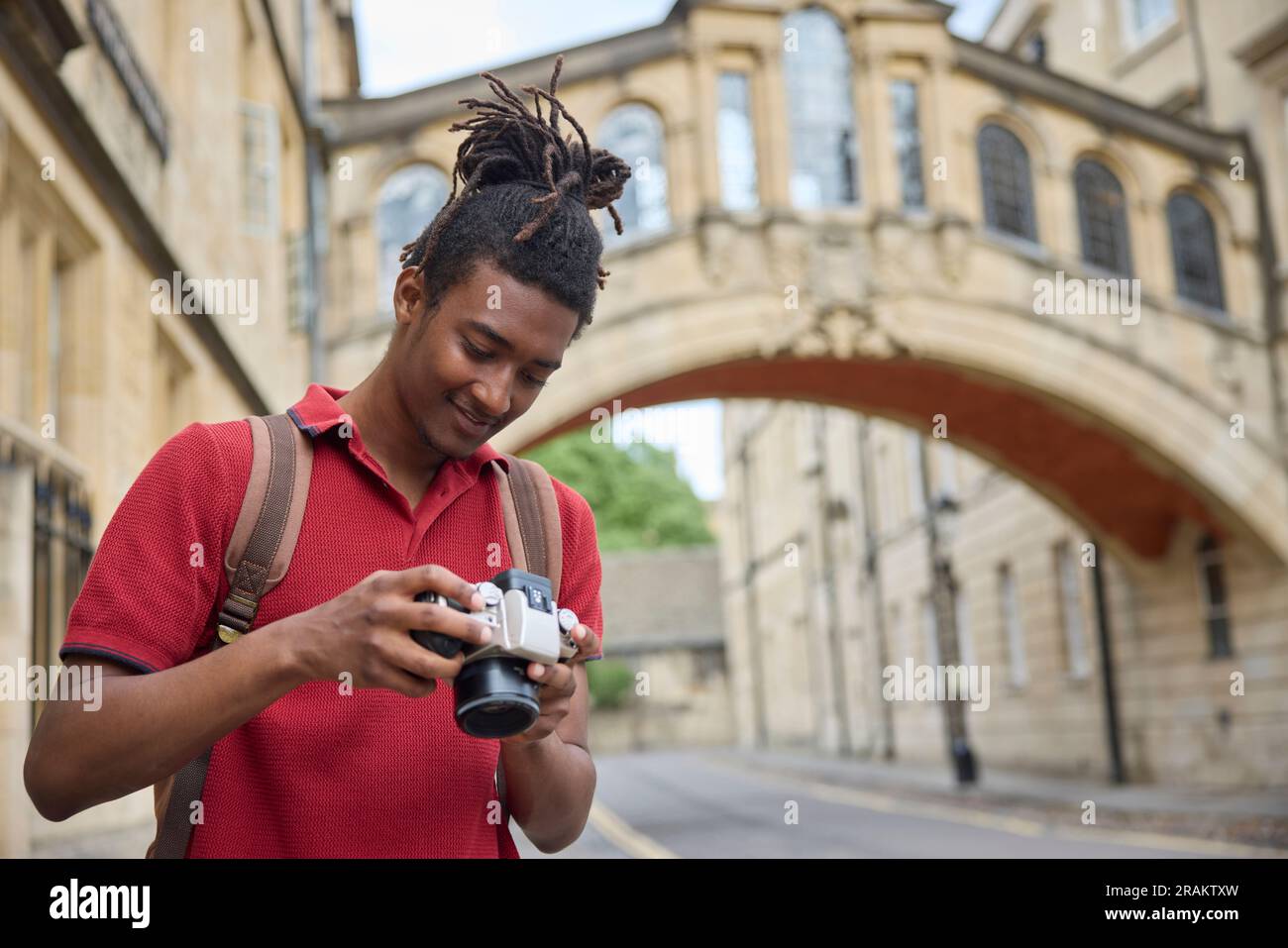 Giovane che viaggia in vacanza scattando foto con la macchina fotografica durante il giro turistico di Oxford Foto Stock