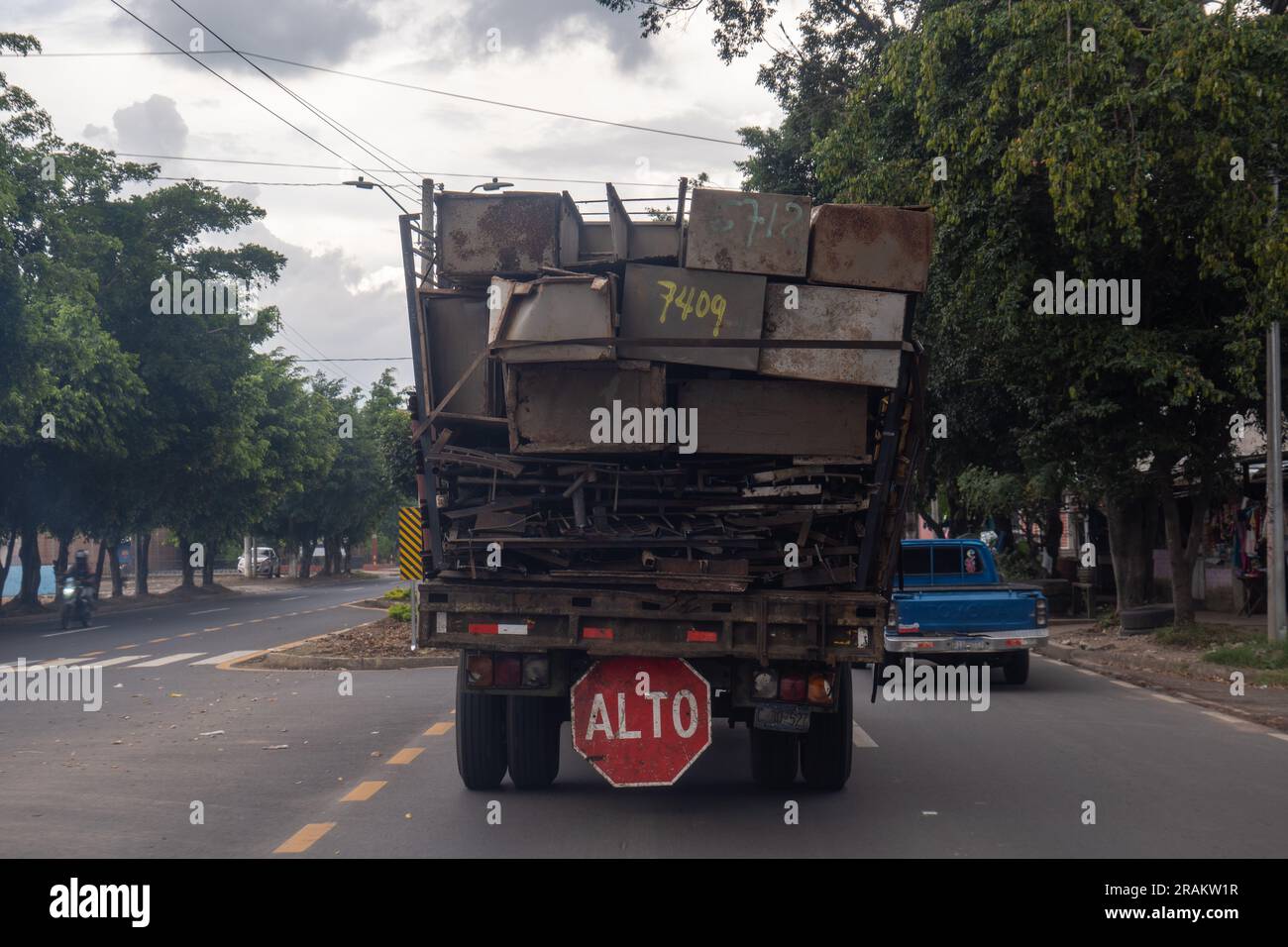 Ahuachapán, El Salvador - 14 novembre 2022: Camion sull'autostrada che trasporta molti mobili in ferro arrugginito con un grande cartello che dice "Stop" Foto Stock