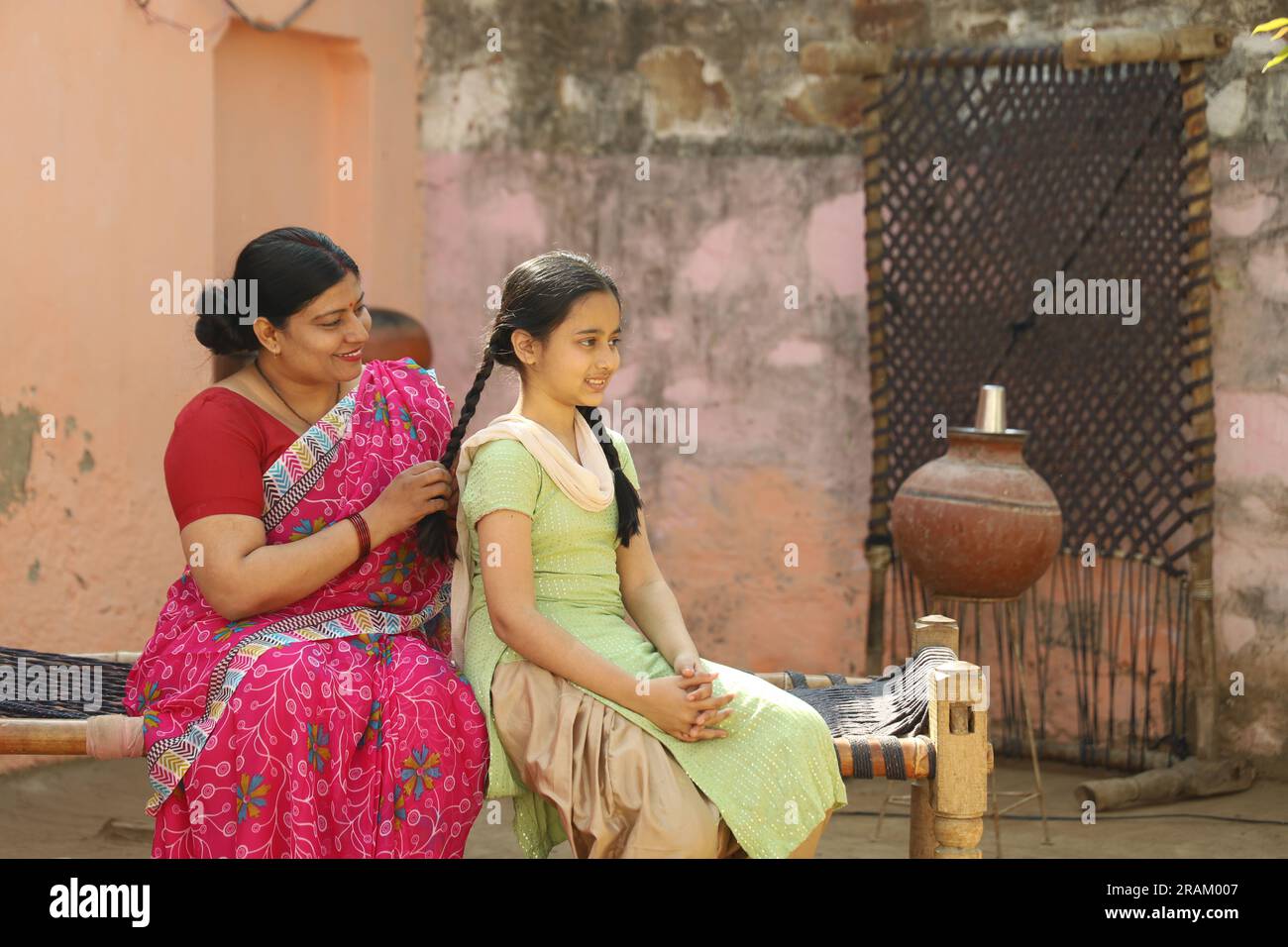 Ritratto della famiglia contadina indiana di una madre e di una figlia seduti insieme nell'abbigliamento di un abitante indiano nel villaggio. Foto Stock