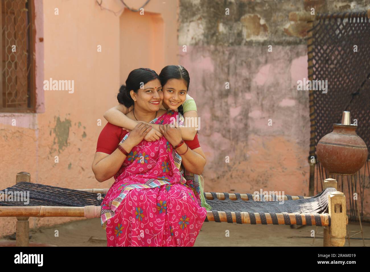 Ritratto della famiglia contadina indiana di una madre e di una figlia seduti insieme nell'abbigliamento di un abitante indiano nel villaggio. Foto Stock