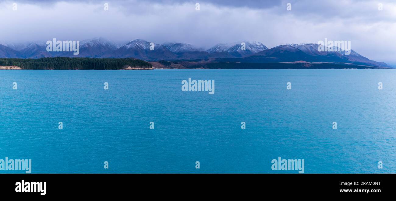 Fotografa il lago Pukaki la mattina presto in una giornata nuvolosa con montagne innevate sullo sfondo dell'Isola del Sud della nuova Zelanda Foto Stock