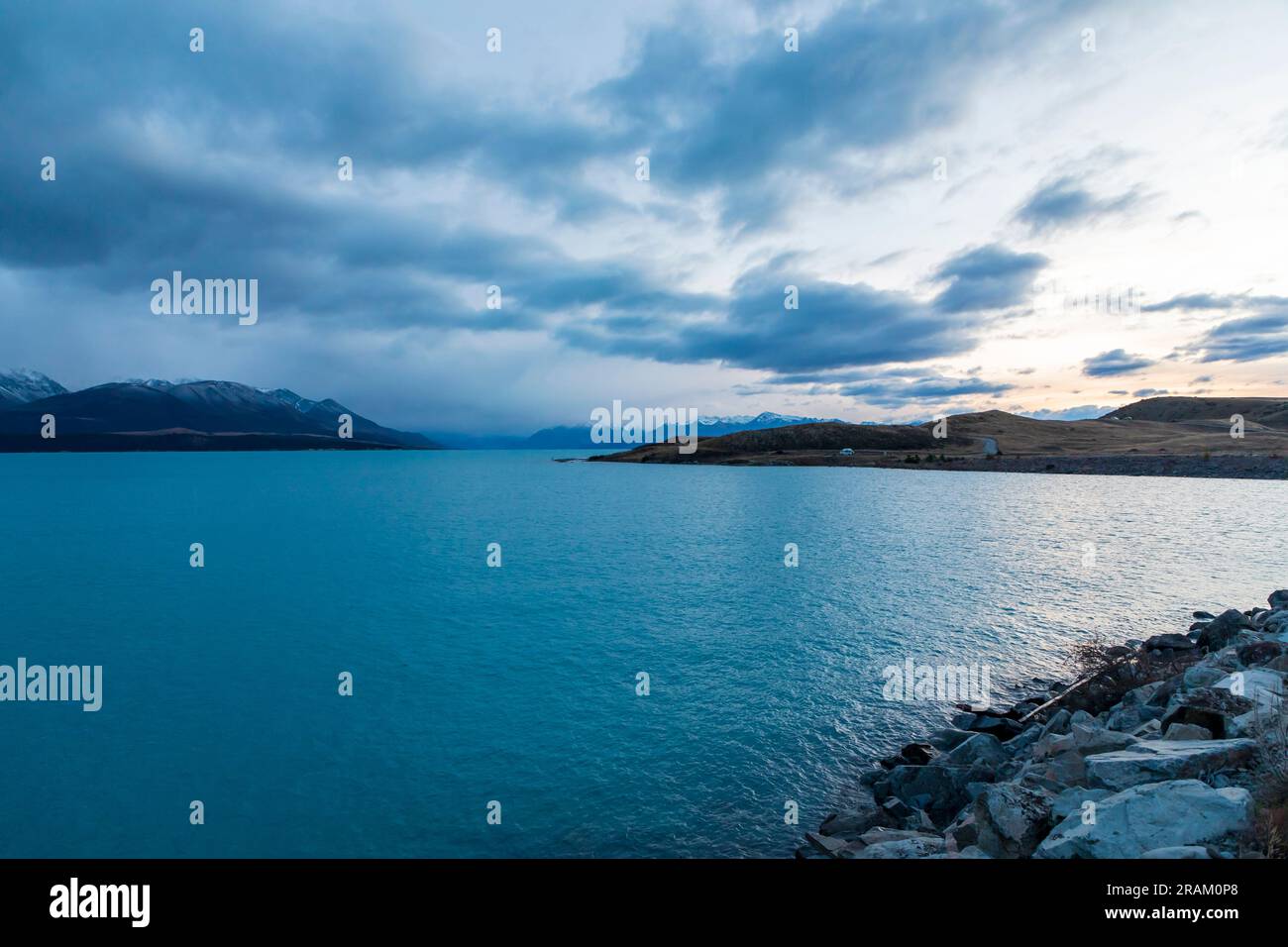 Fotografa il lago Pukaki la mattina presto in una giornata nuvolosa con montagne innevate sullo sfondo dell'Isola del Sud della nuova Zelanda Foto Stock